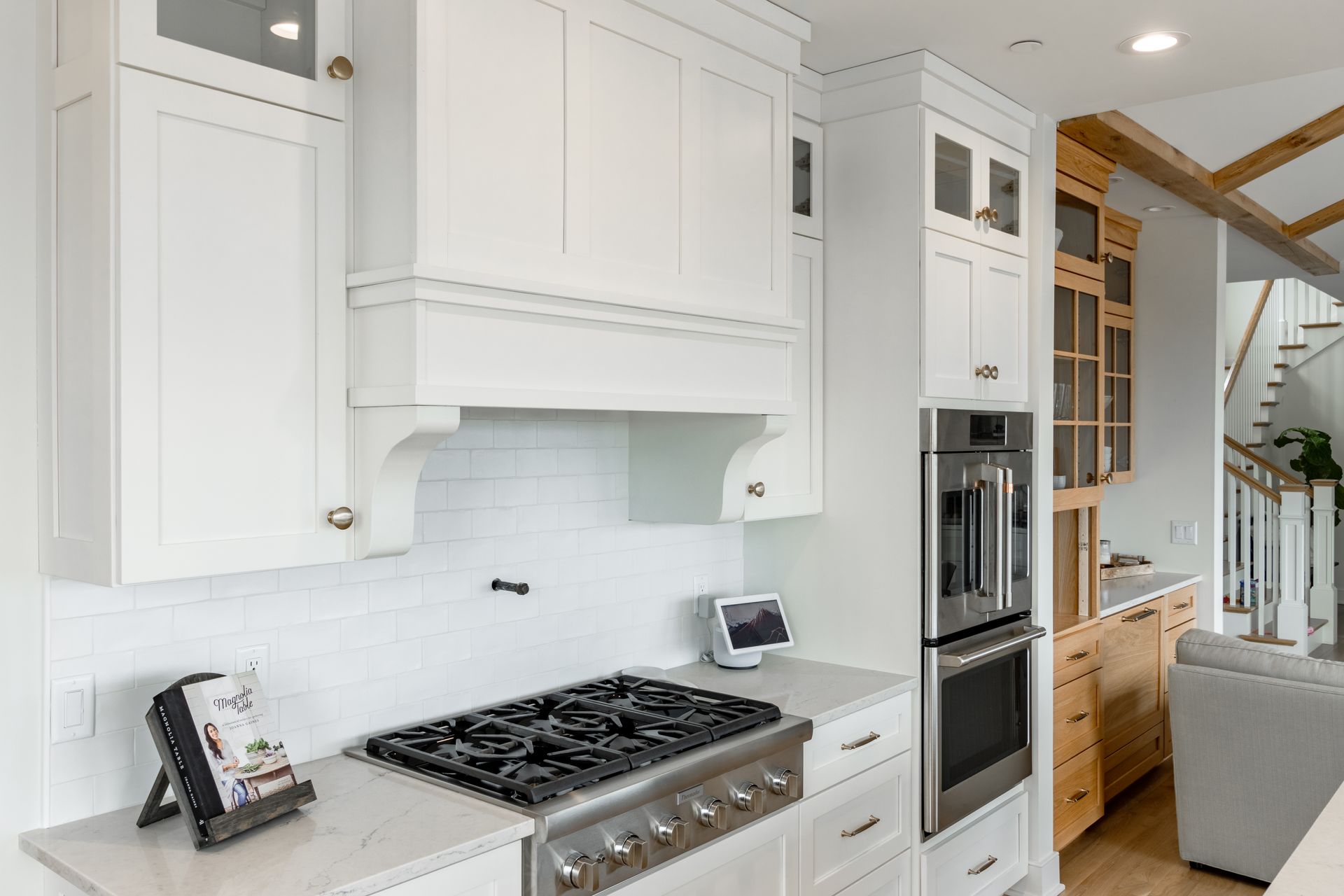 White kitchen with stainless steel appliances, white cabinets, and gas cooktop.