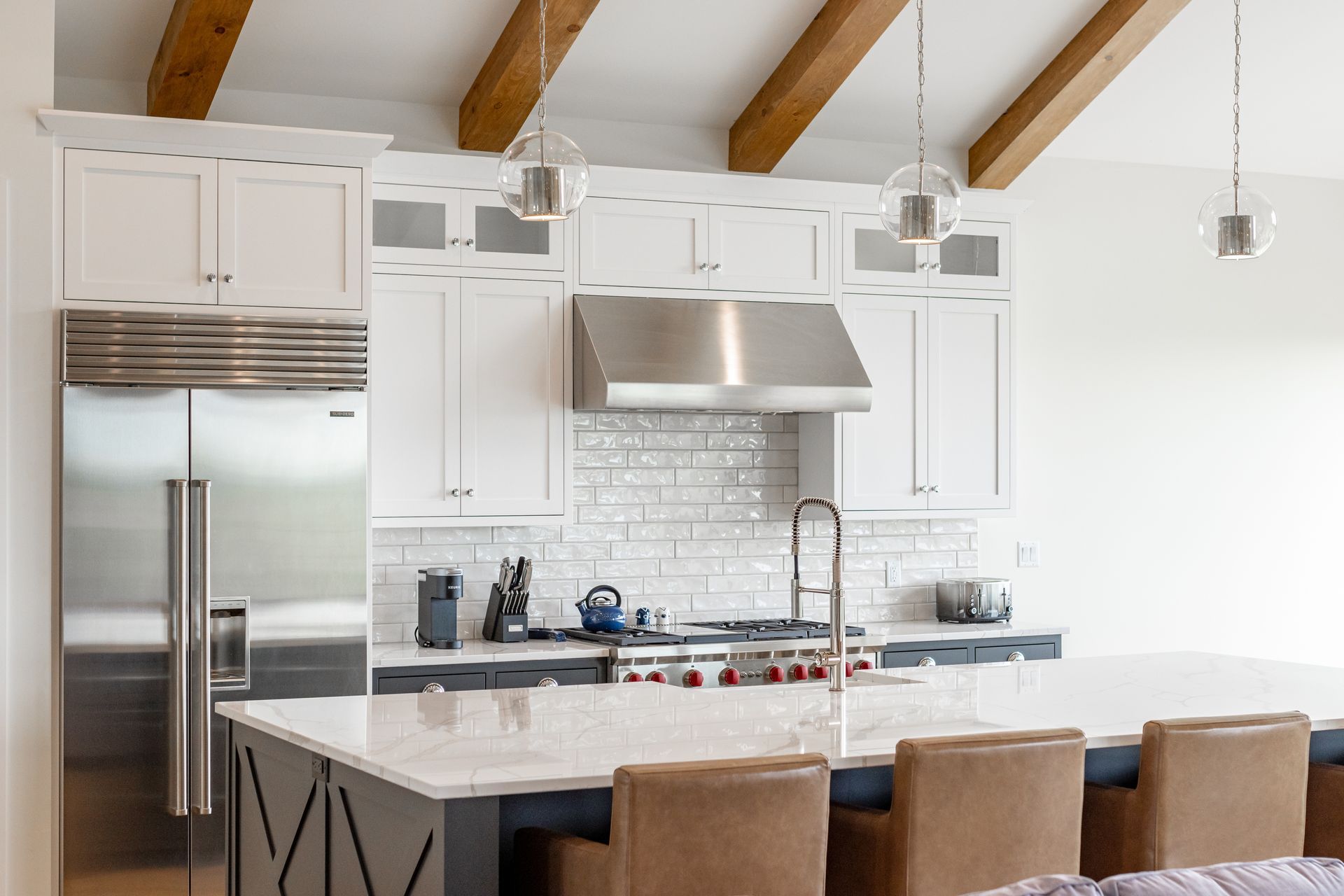 Modern kitchen with white cabinets, stainless steel appliances, and large island with seating.