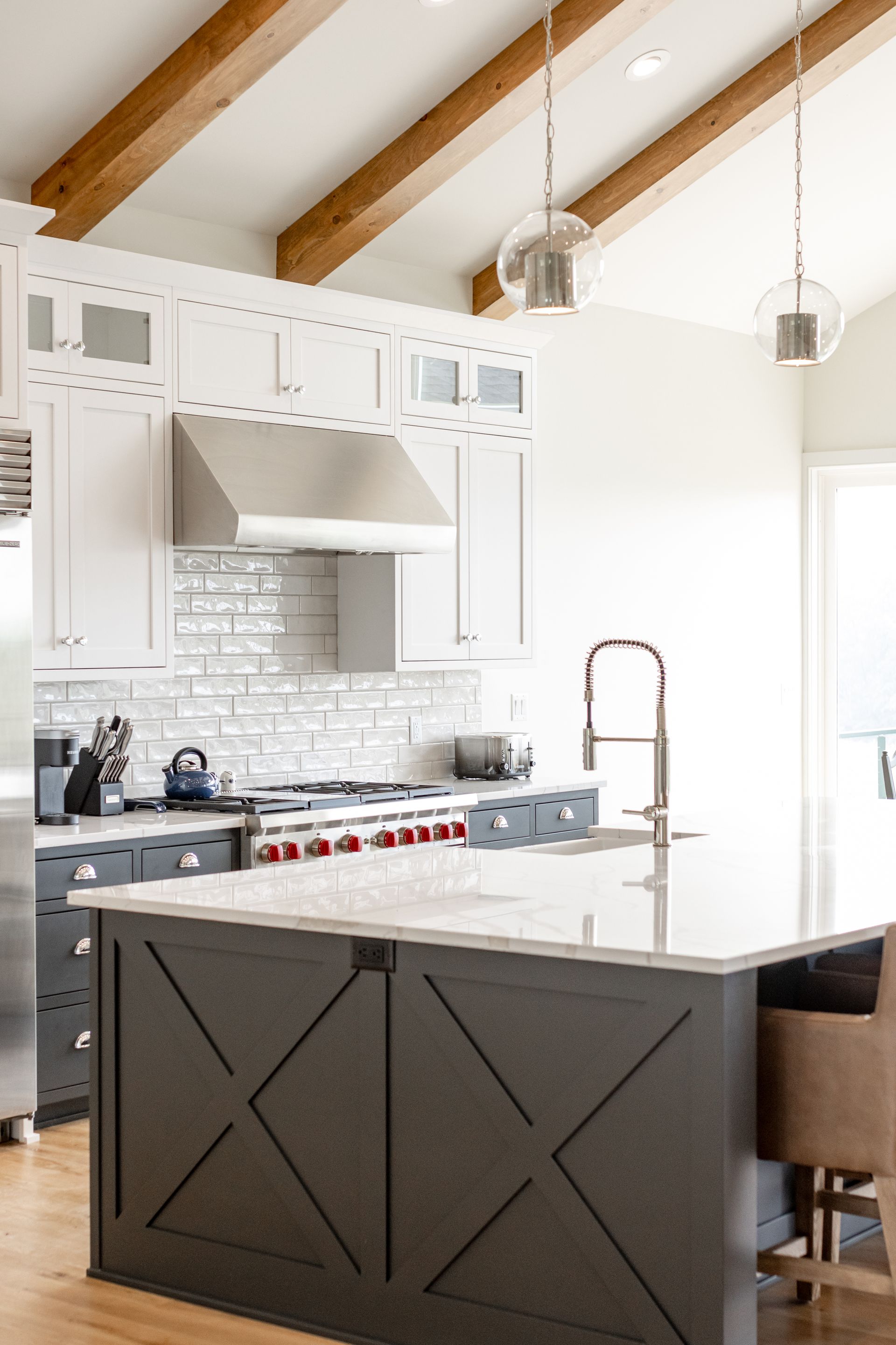 Modern kitchen with white and gray cabinets, island, and stainless steel appliances.