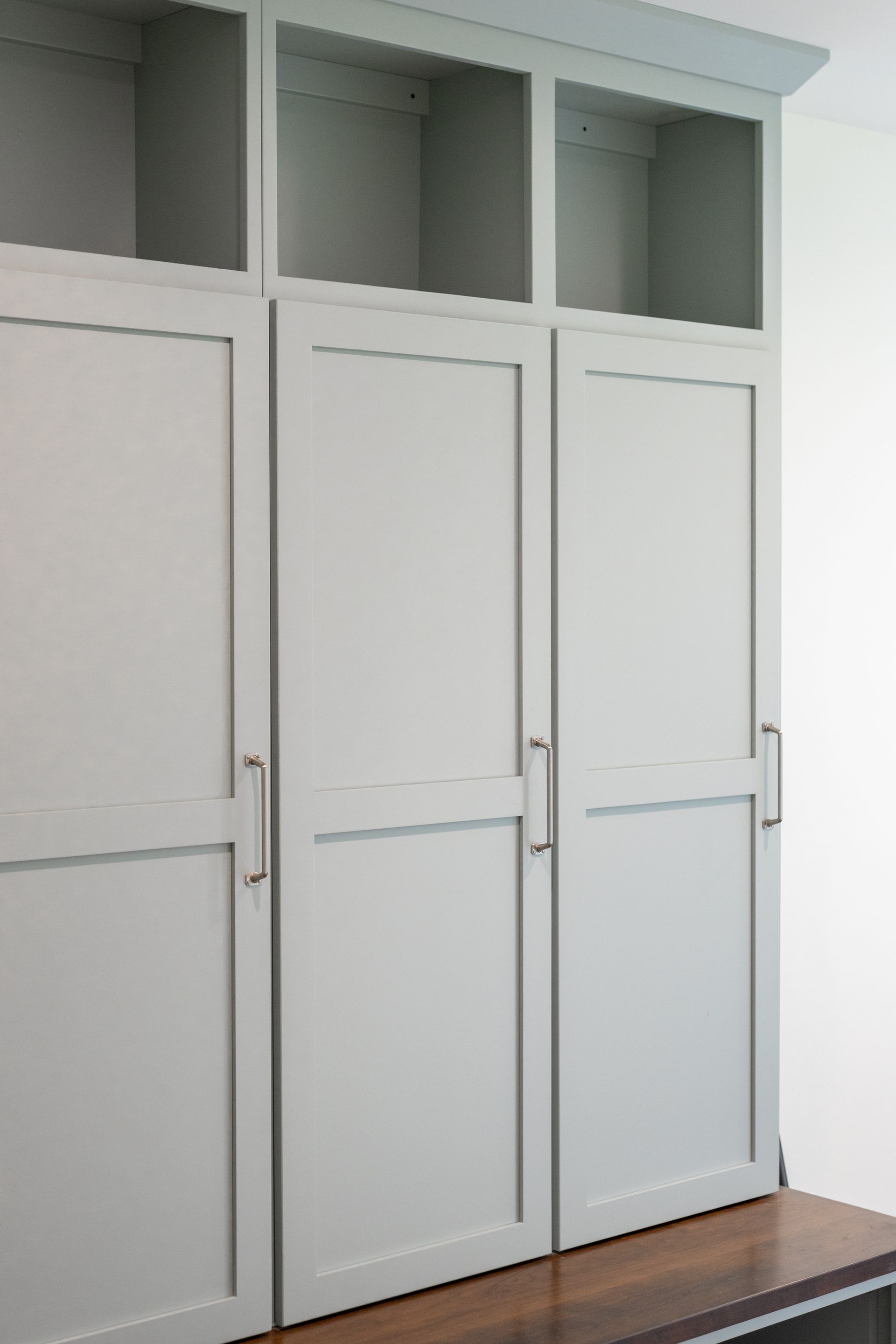 Light blue cabinets with three doors, above open shelving.