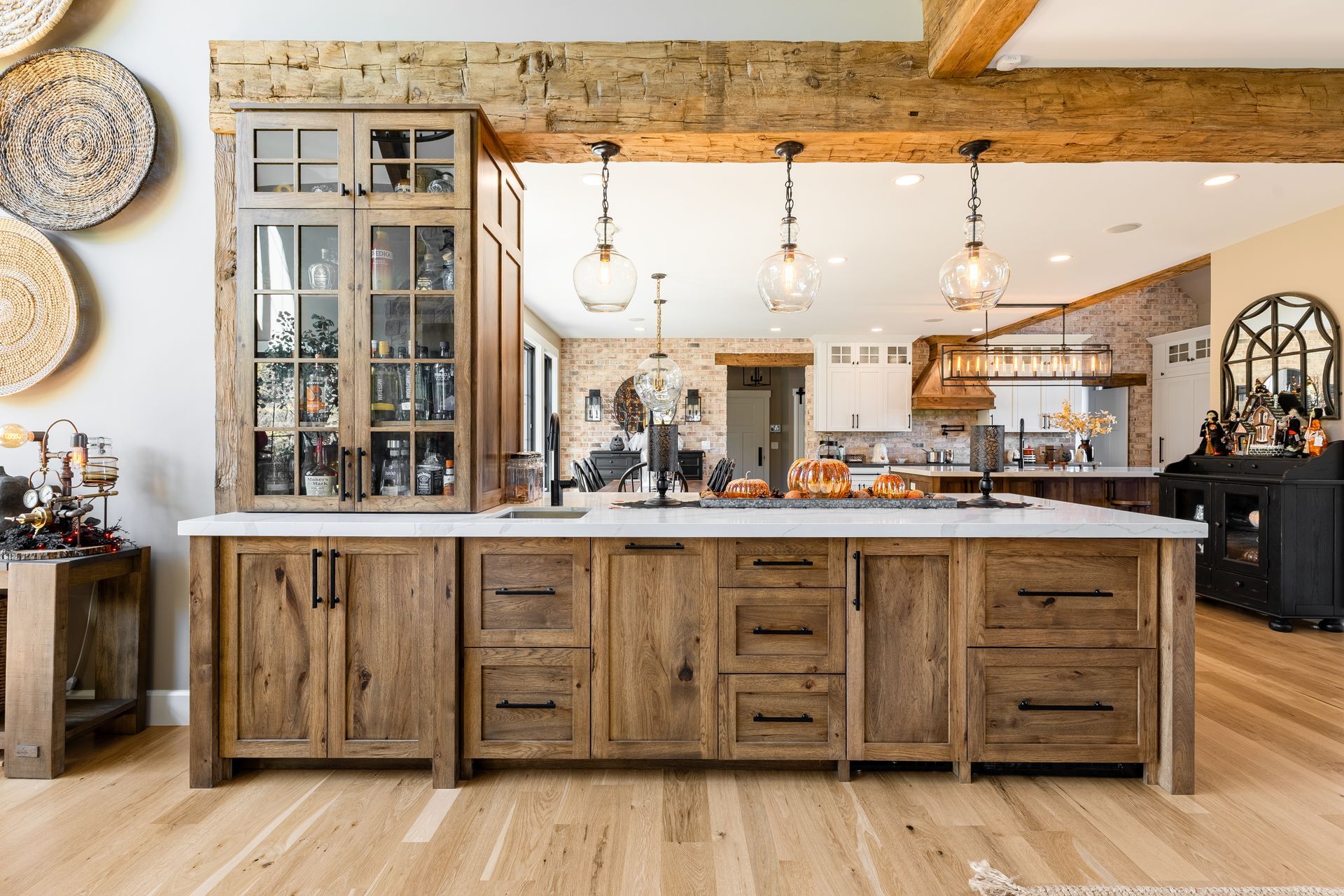 Rustic kitchen with wooden cabinets, island, and overhead lighting.