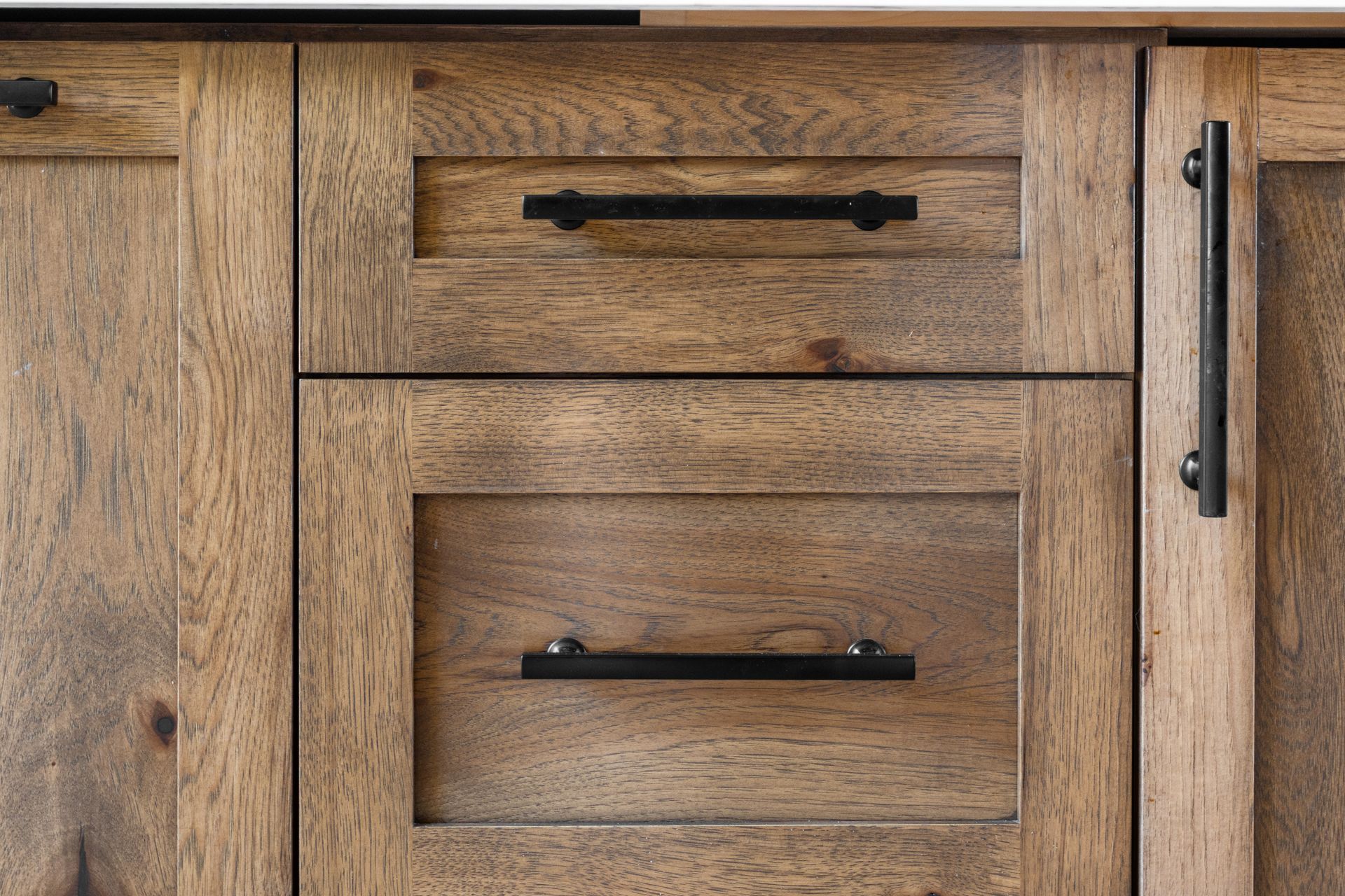 Wooden cabinet with two drawers and a door. Black hardware.