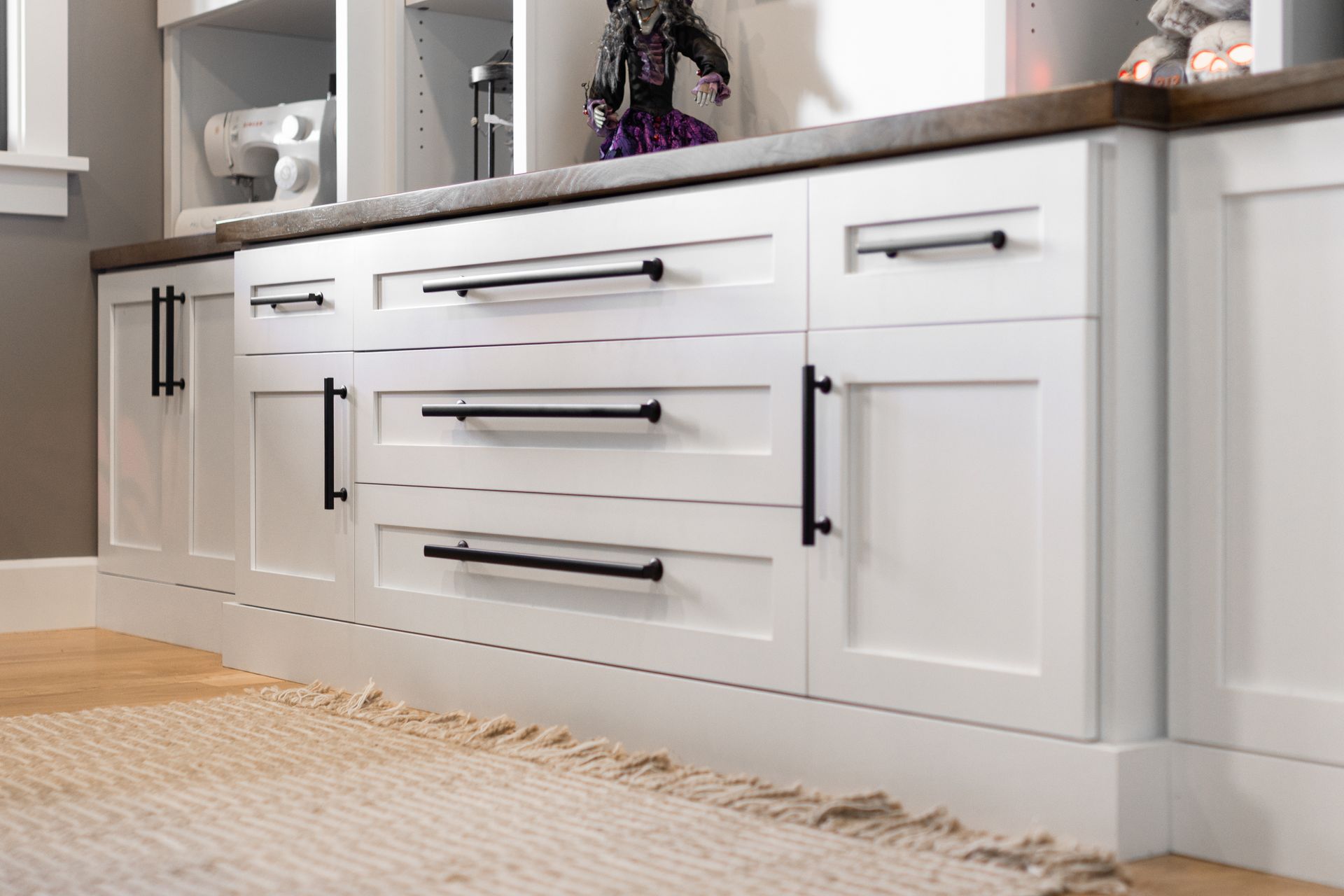 White cabinets with black handles and a dark countertop.