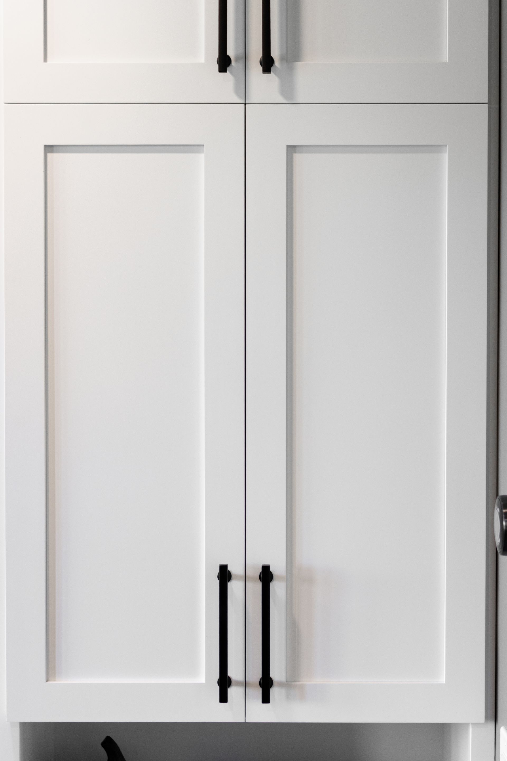 White kitchen cabinets with black handles.