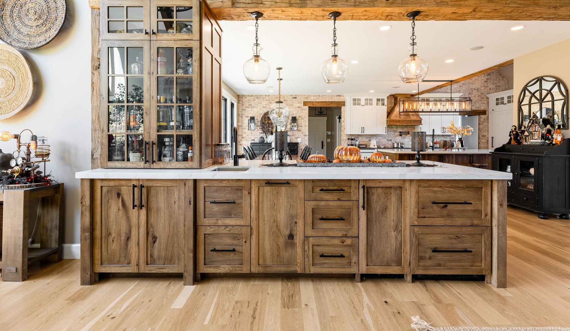 Rustic kitchen with wood cabinets, island, and glass-front display.