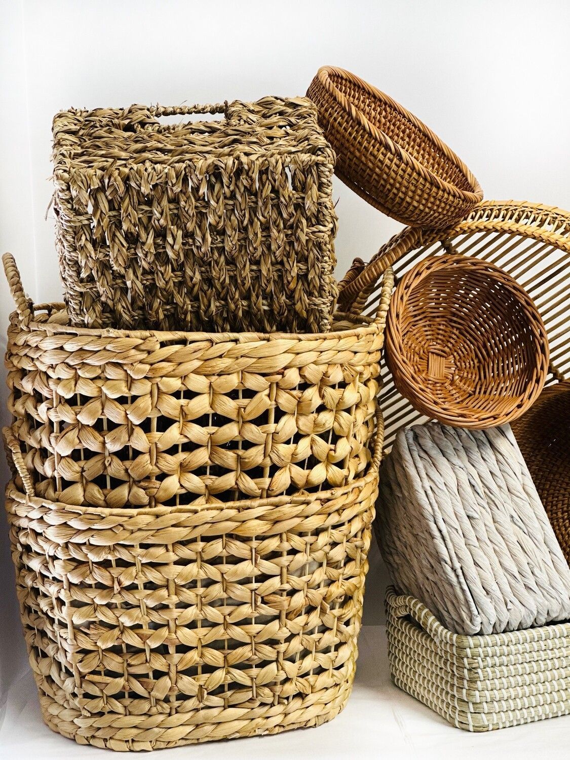 A bunch of wicker baskets are stacked on top of each other on a table.