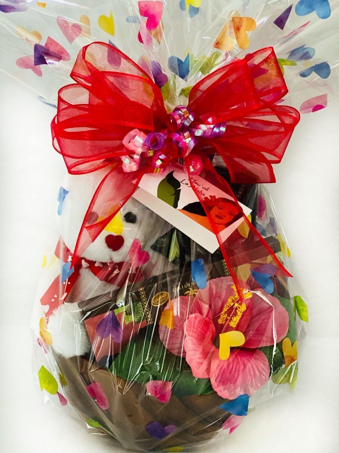 a gift wrapped in plastic with flowers and a red bow