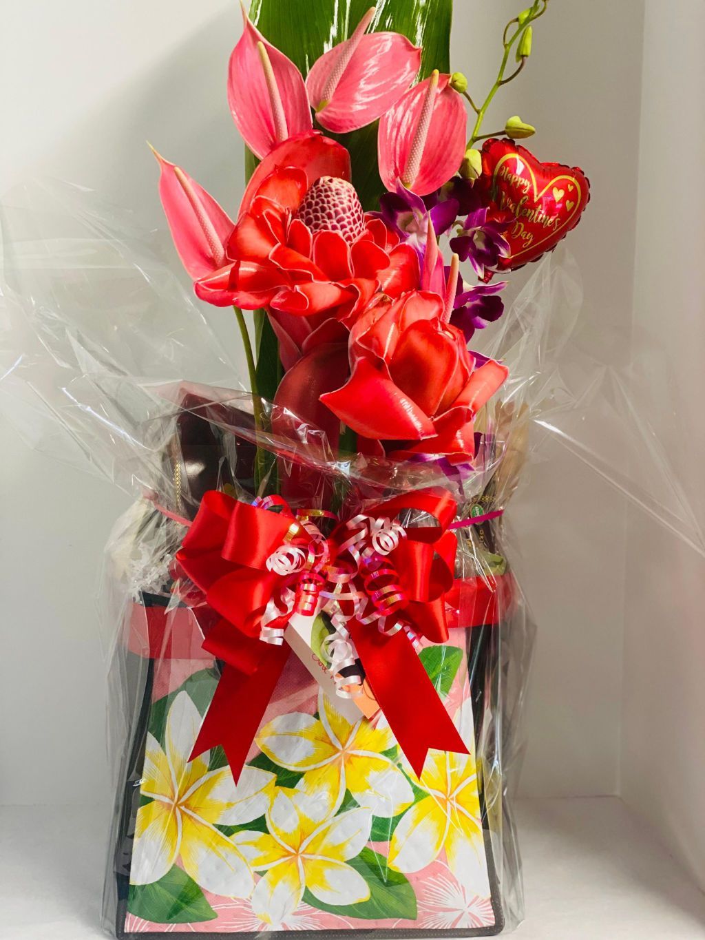 a vase filled with flowers and a heart shaped balloon .