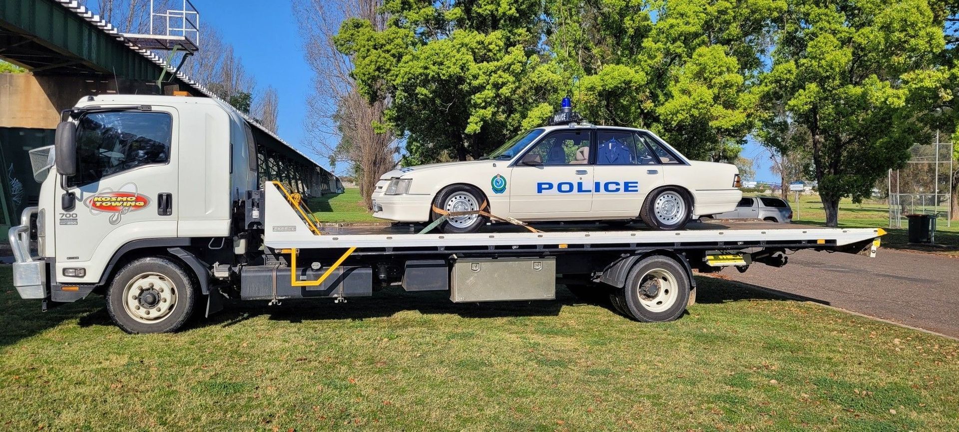 A police car is being towed by a tow truck.