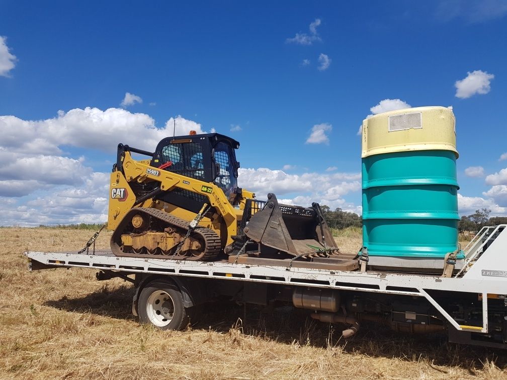 A bulldozer is sitting on top of a flatbed truck.