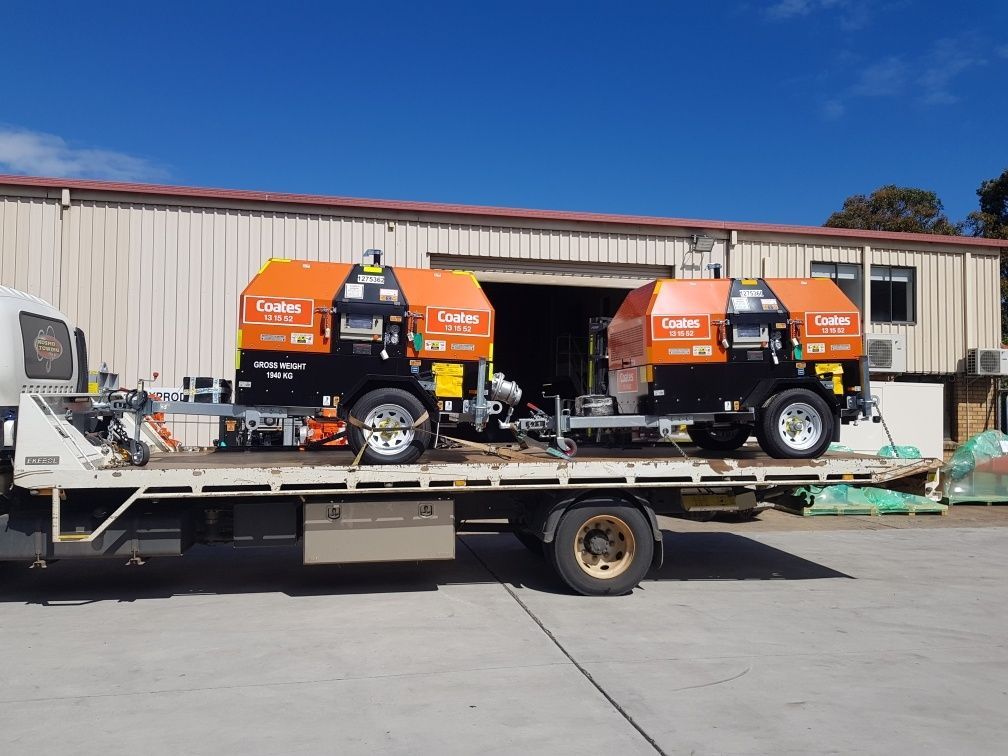 A tow truck with two machinery on the back of it