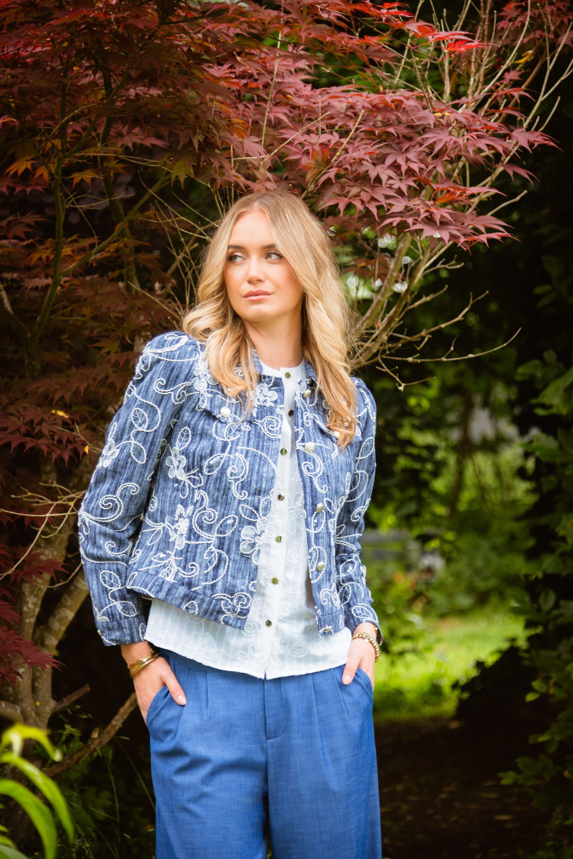 Een vrouw in een blauwe jas en broek van ICNK