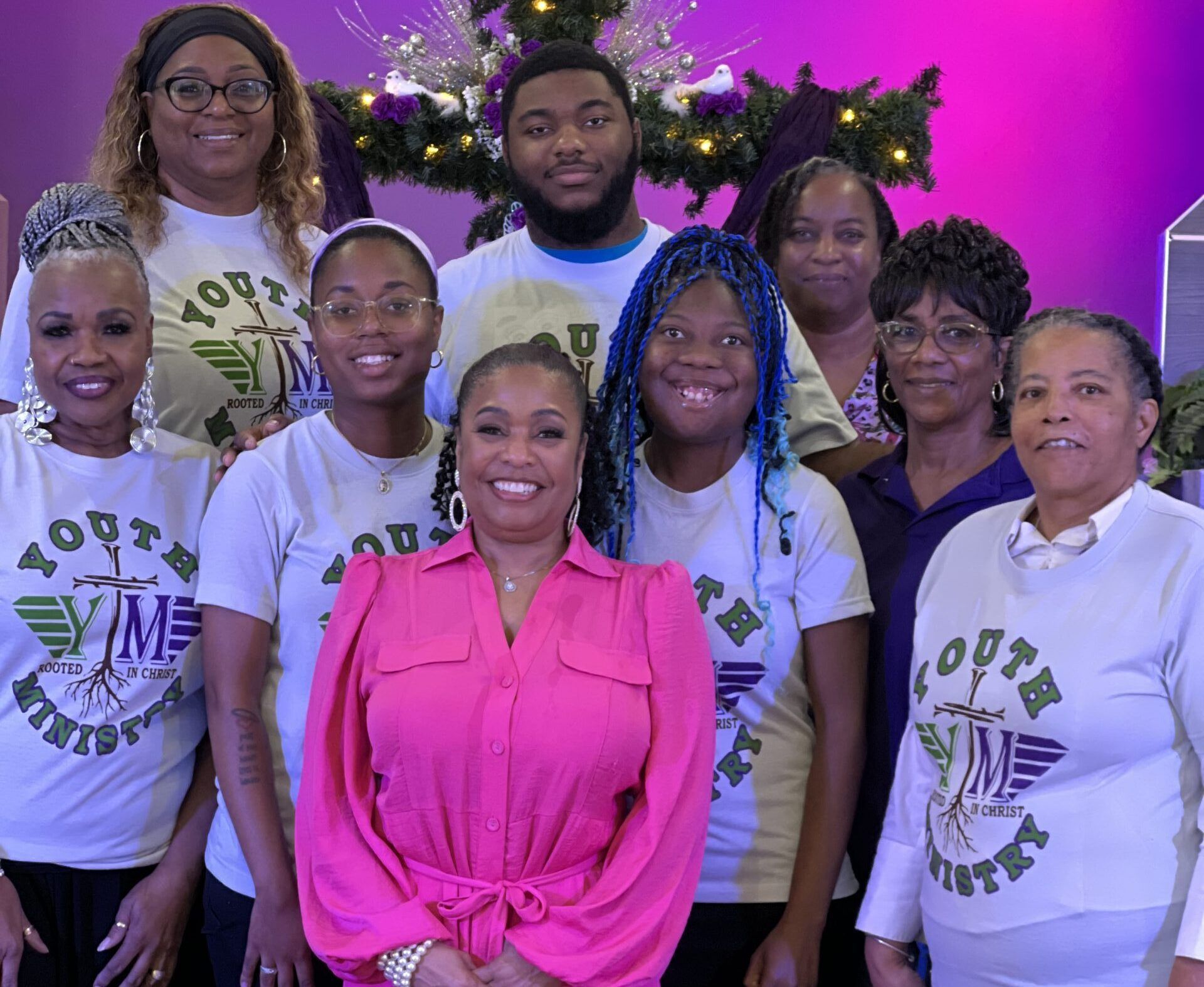 A group of nine people wearing white shirts with a 