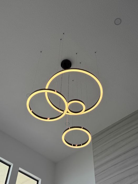 Modern ceiling light with four glowing circular rings against a white ceiling