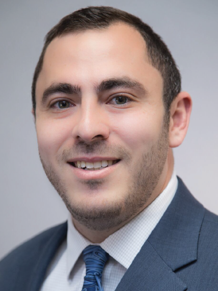 A man in a suit and tie is smiling for the camera.