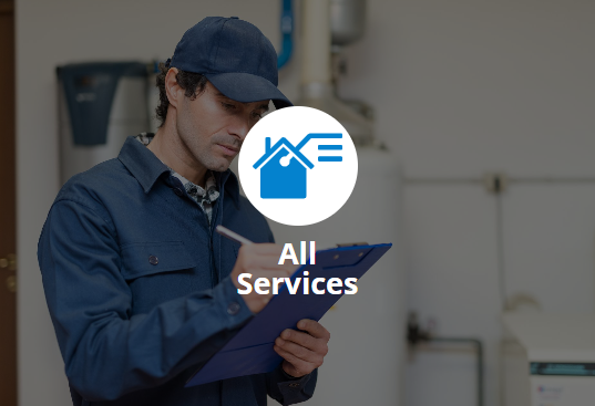 A technician in blue overalls and cap taking notes in front of a water heater, with