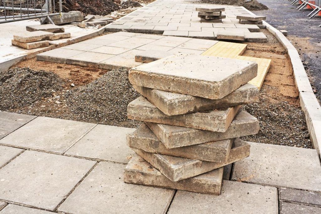 A pile of bricks sitting on top of each other on a sidewalk.