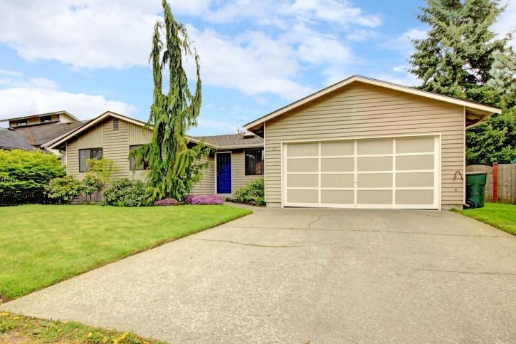 A house with a garage and a driveway in front of it.