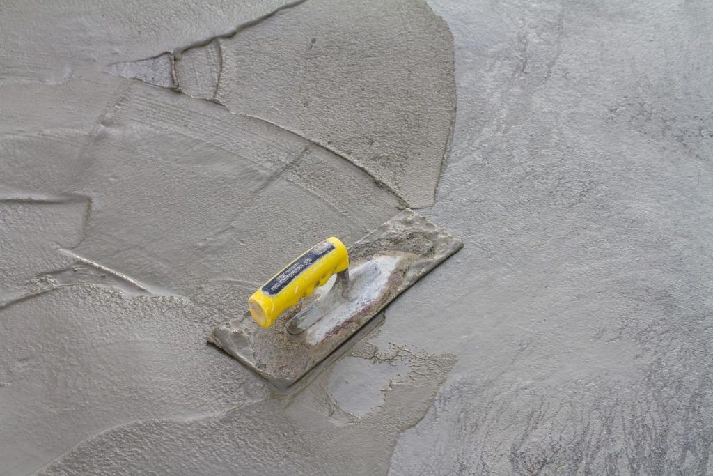 A trowel is sitting on top of a pile of concrete.