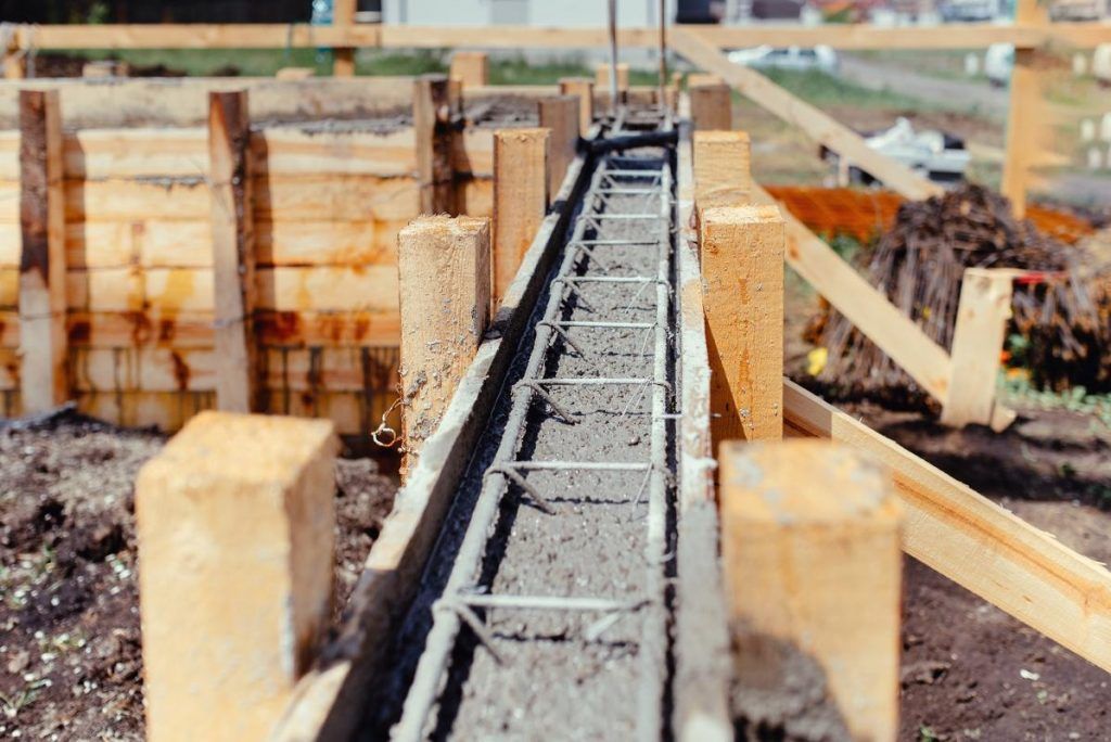 A concrete foundation is being built on a construction site.