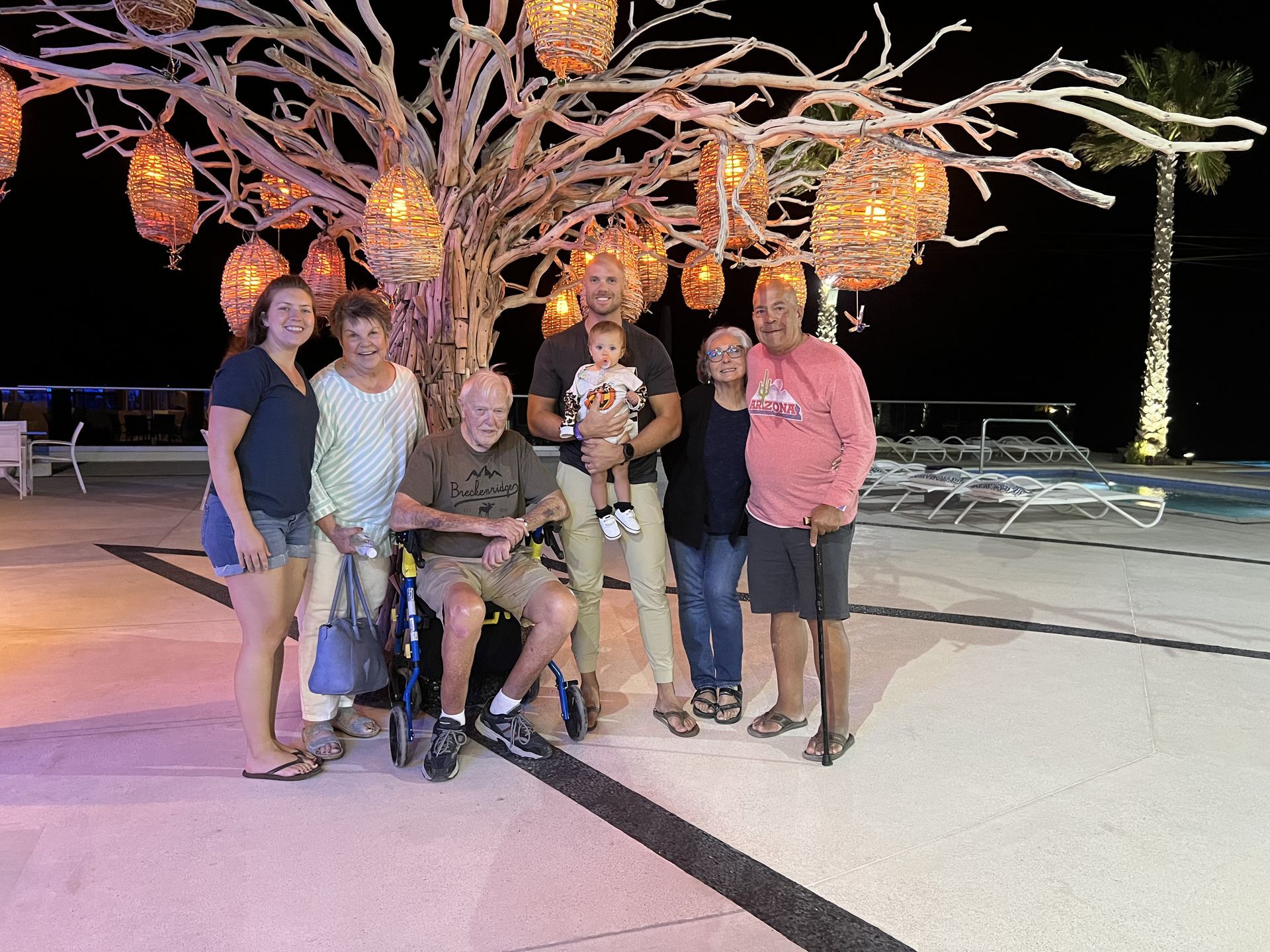 A group of people are posing for a picture in front of a tree.
