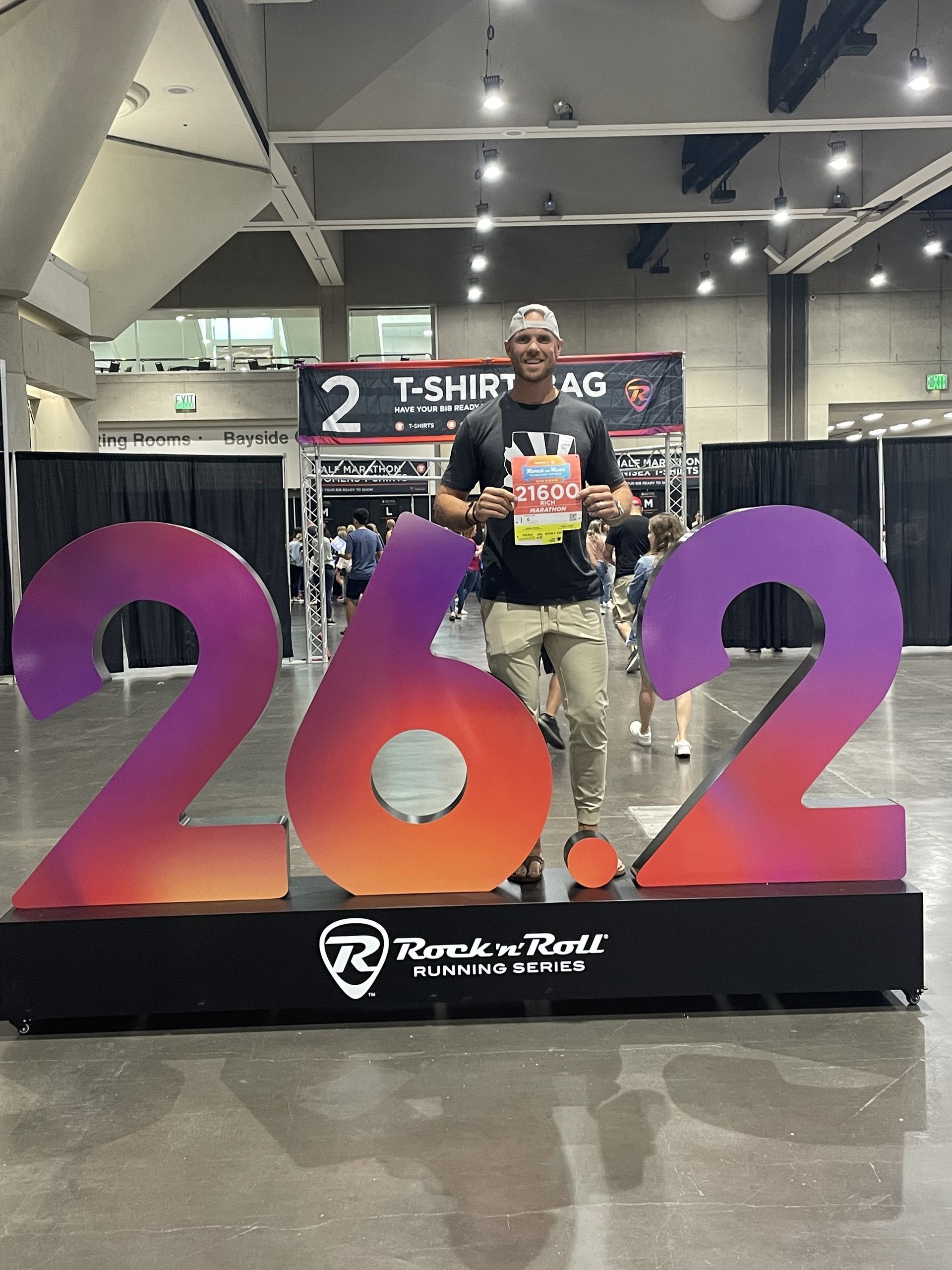 A man is standing in front of a large number 262 sign.