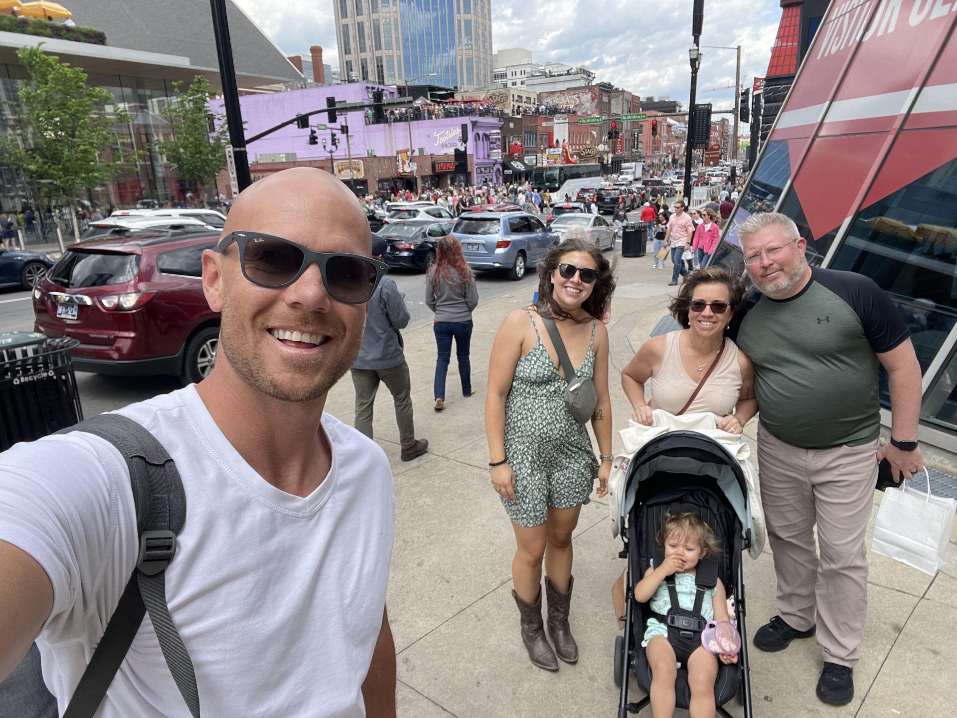 A group of people are posing for a picture on a city street.