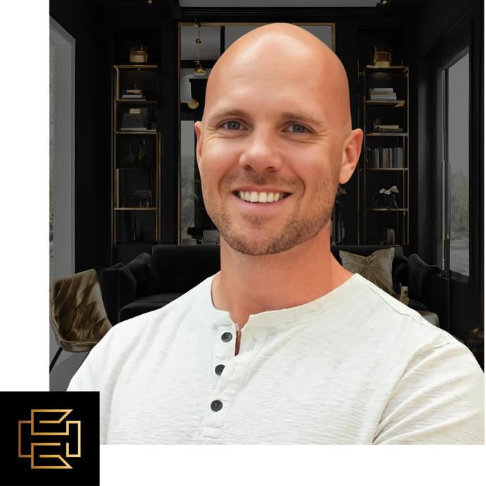 A bald man with a beard is smiling in front of a living room.