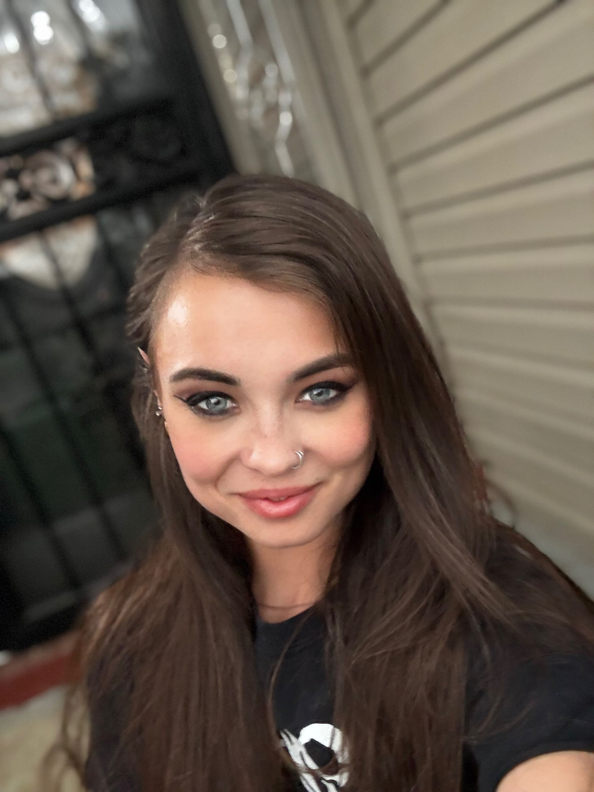 A woman with long hair and blue eyes is smiling for the camera.