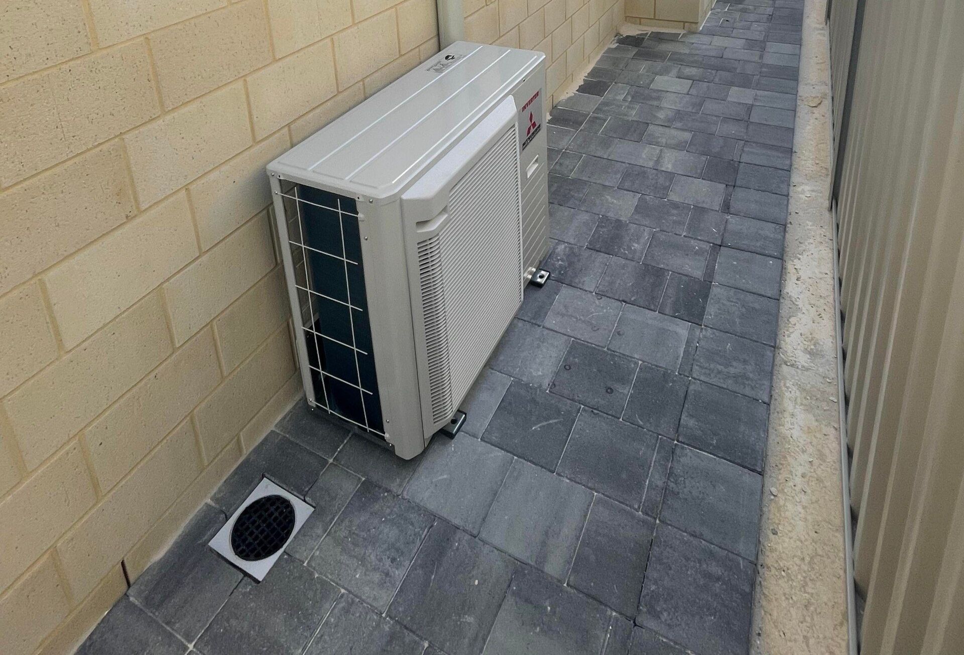 Outdoor Split System Air Conditioning Unit Installed on External Wall of House