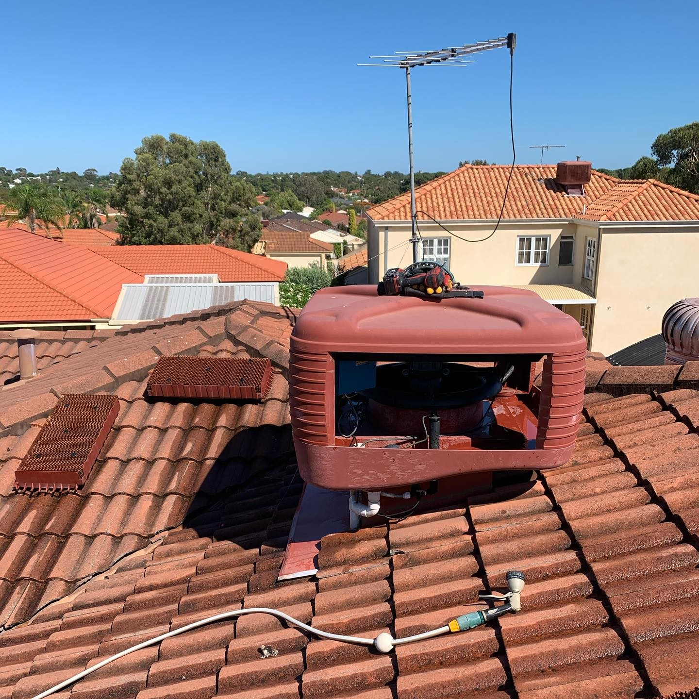 Evap air conditioning maintenance and clean on red tiled house roof