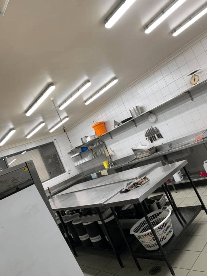 Restaurant kitchen having lights installed over stainless bench