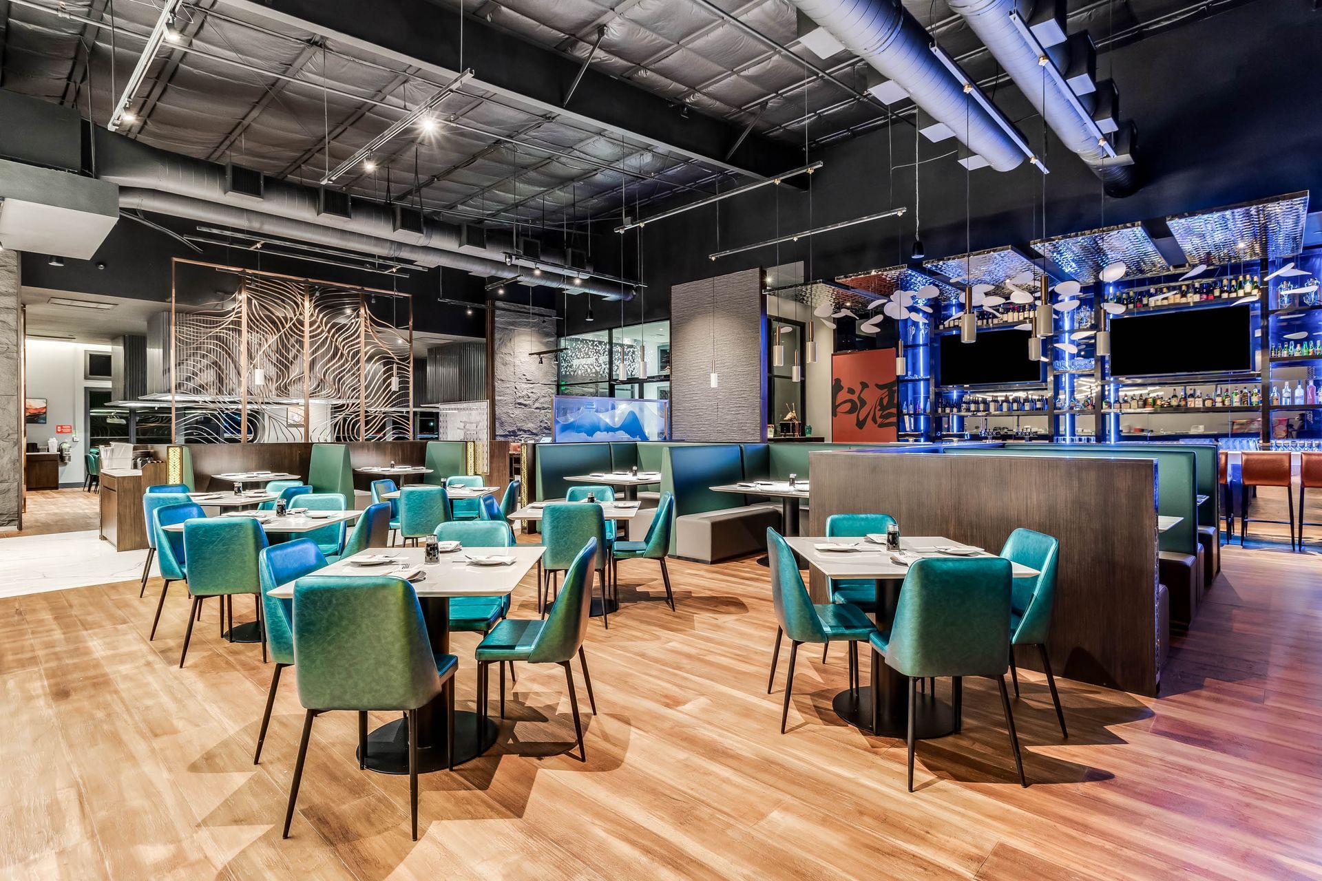 A restaurant with tables and chairs and a wooden floor.