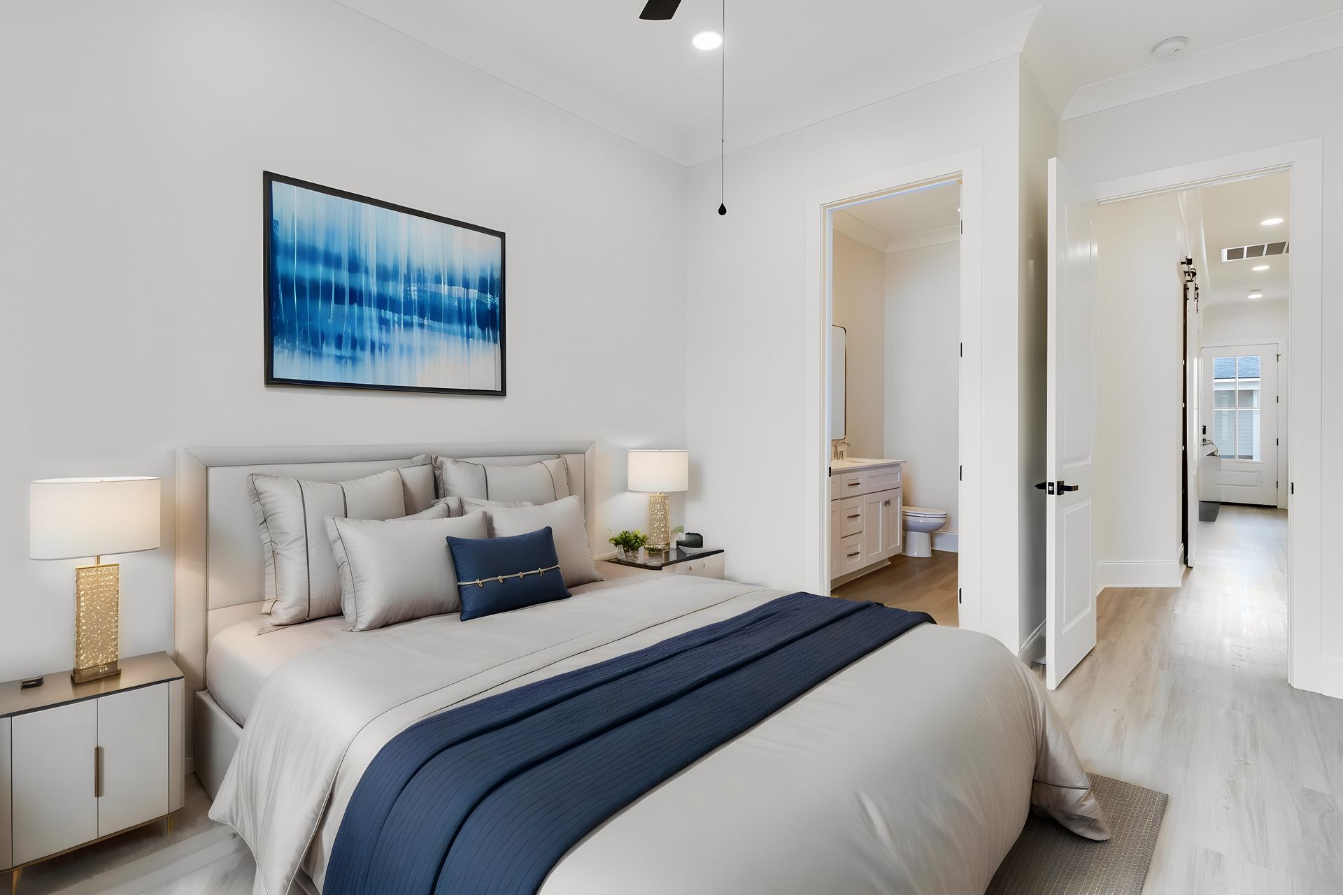 A bedroom with a large bed and a painting on the wall.