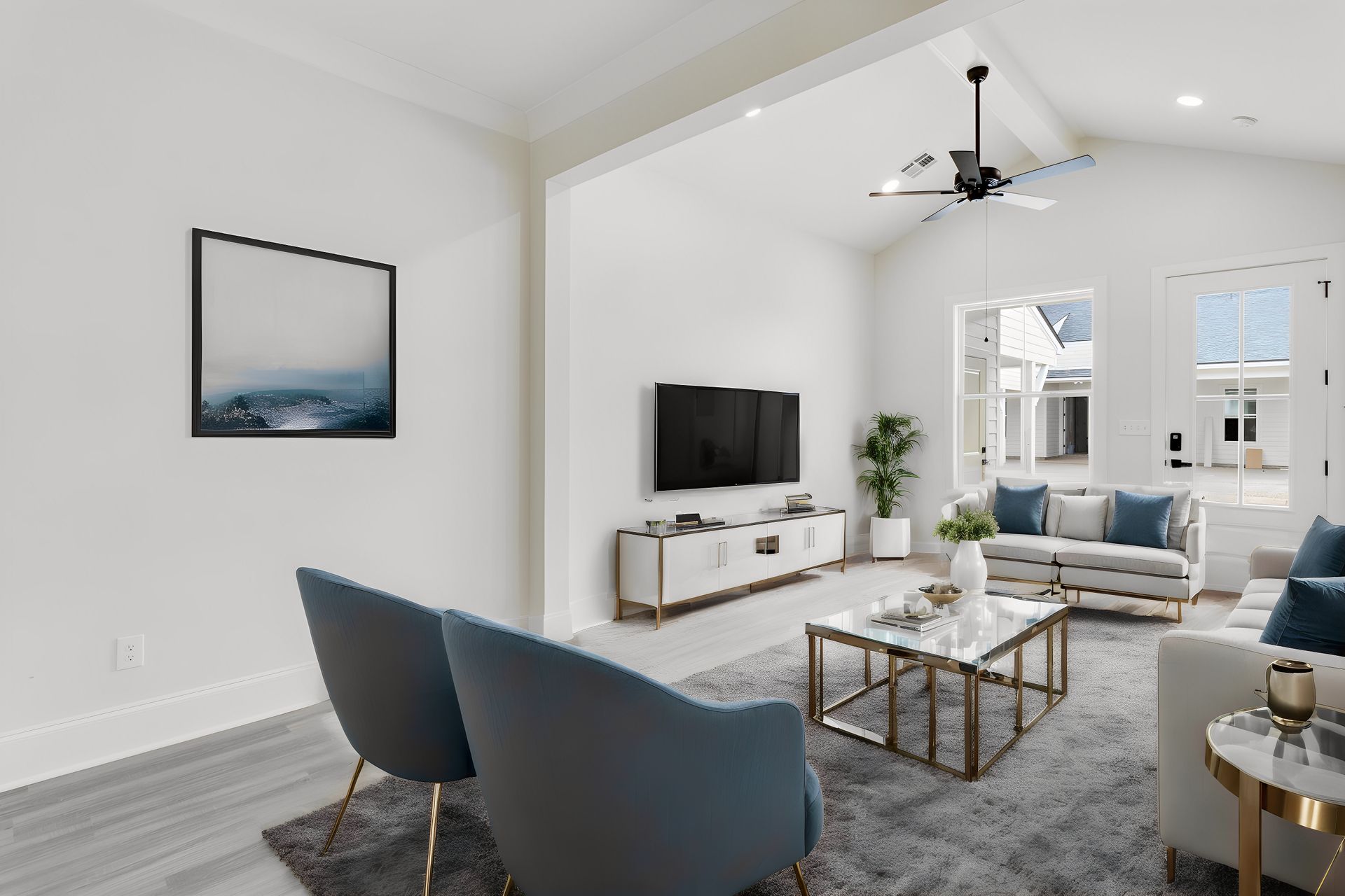 A living room with a ceiling fan and a flat screen tv.