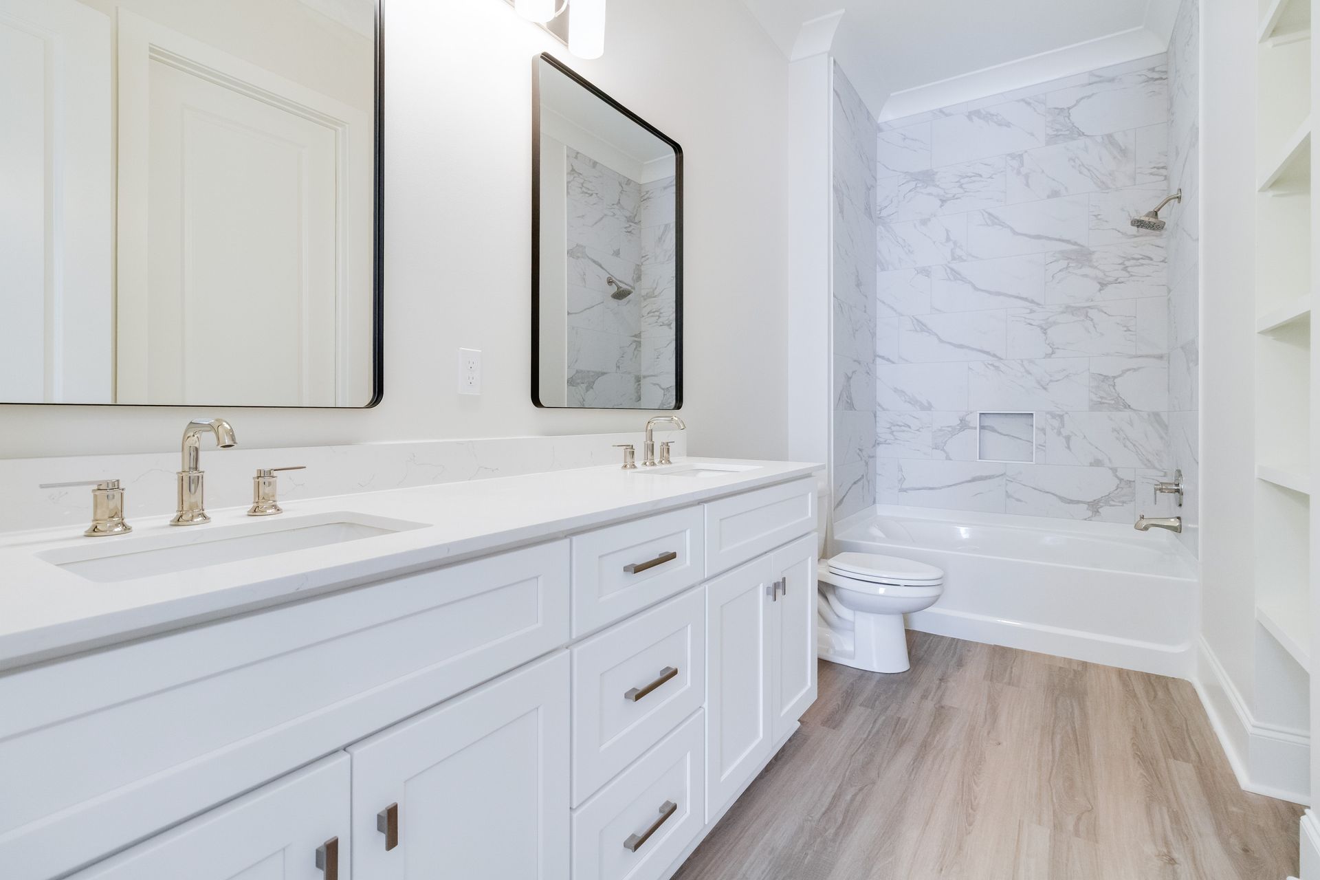 A bathroom with two sinks , a toilet , and a bathtub.