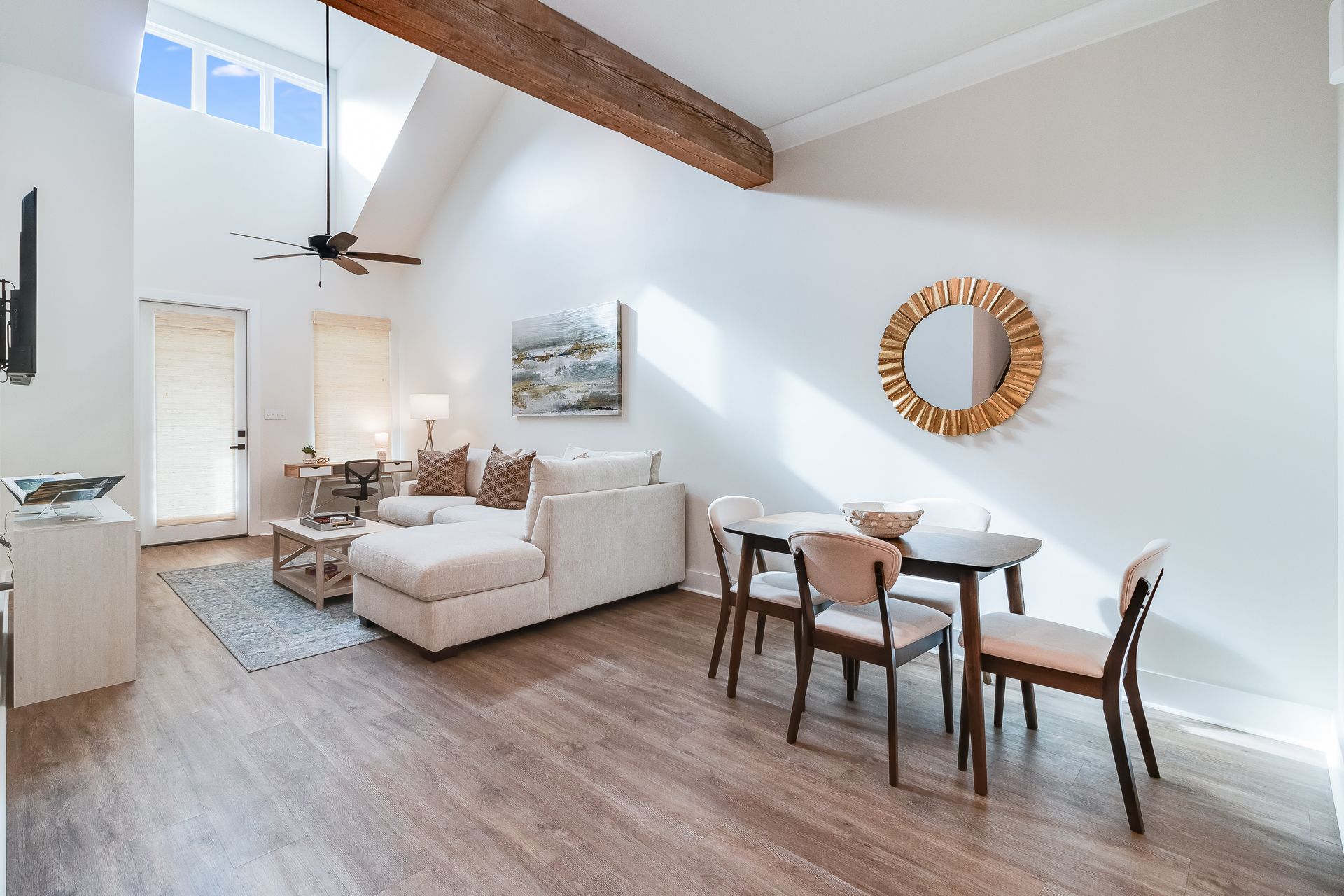 A living room with a dining table and chairs and a ceiling fan.