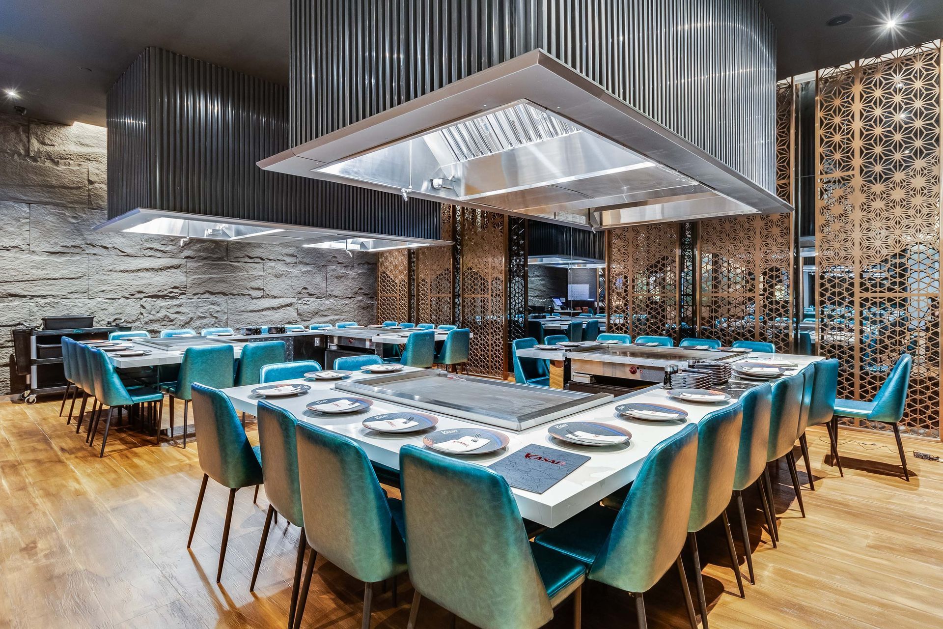 A large dining room with tables and chairs and a grill.