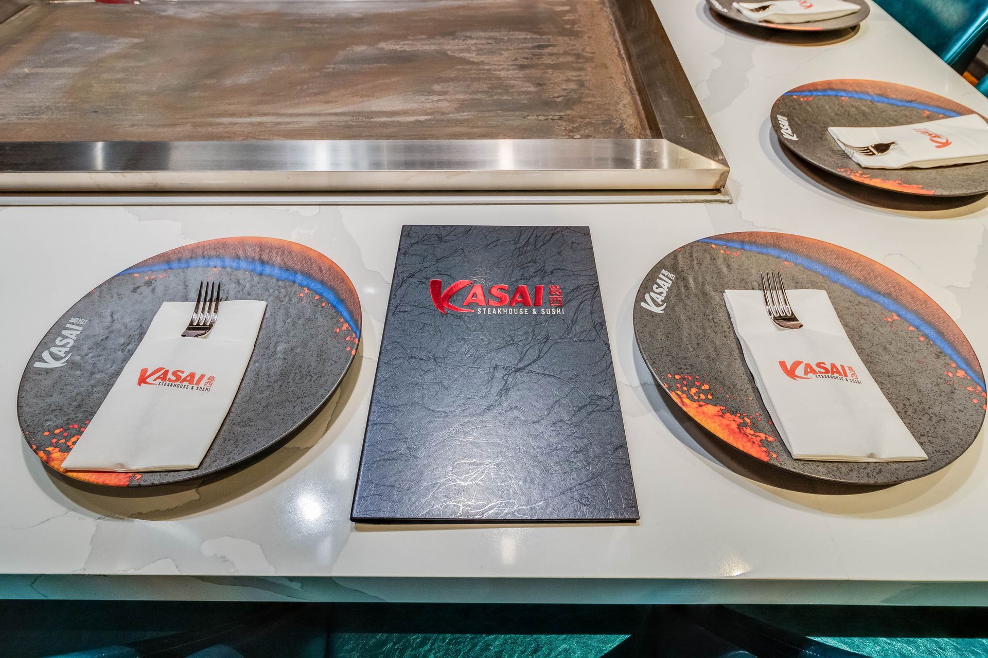 A table with plates , napkins , and a menu on it.