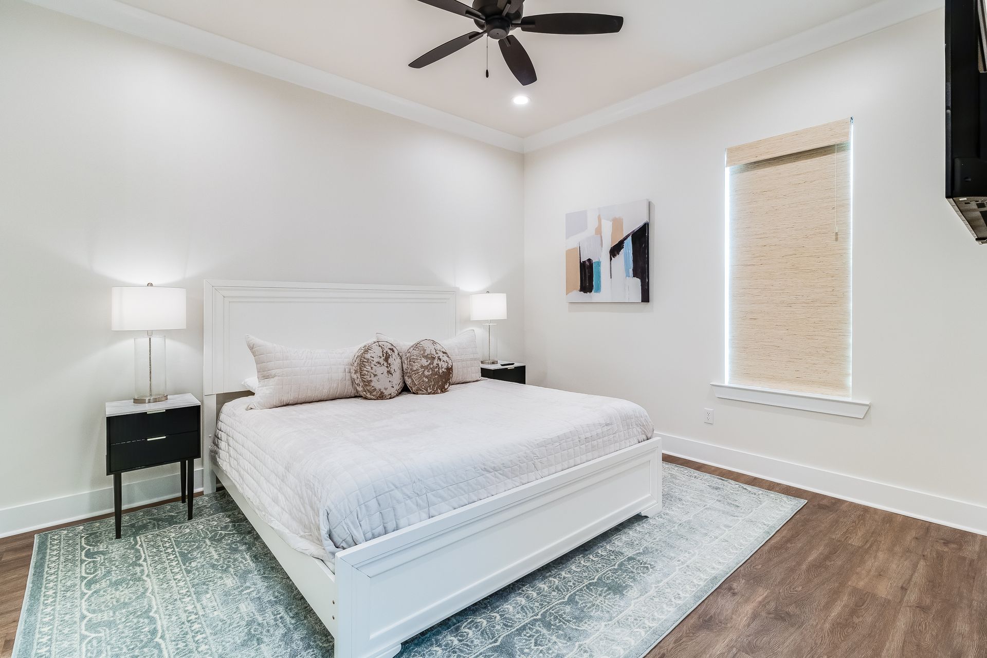 A bedroom with a king size bed and a ceiling fan.
