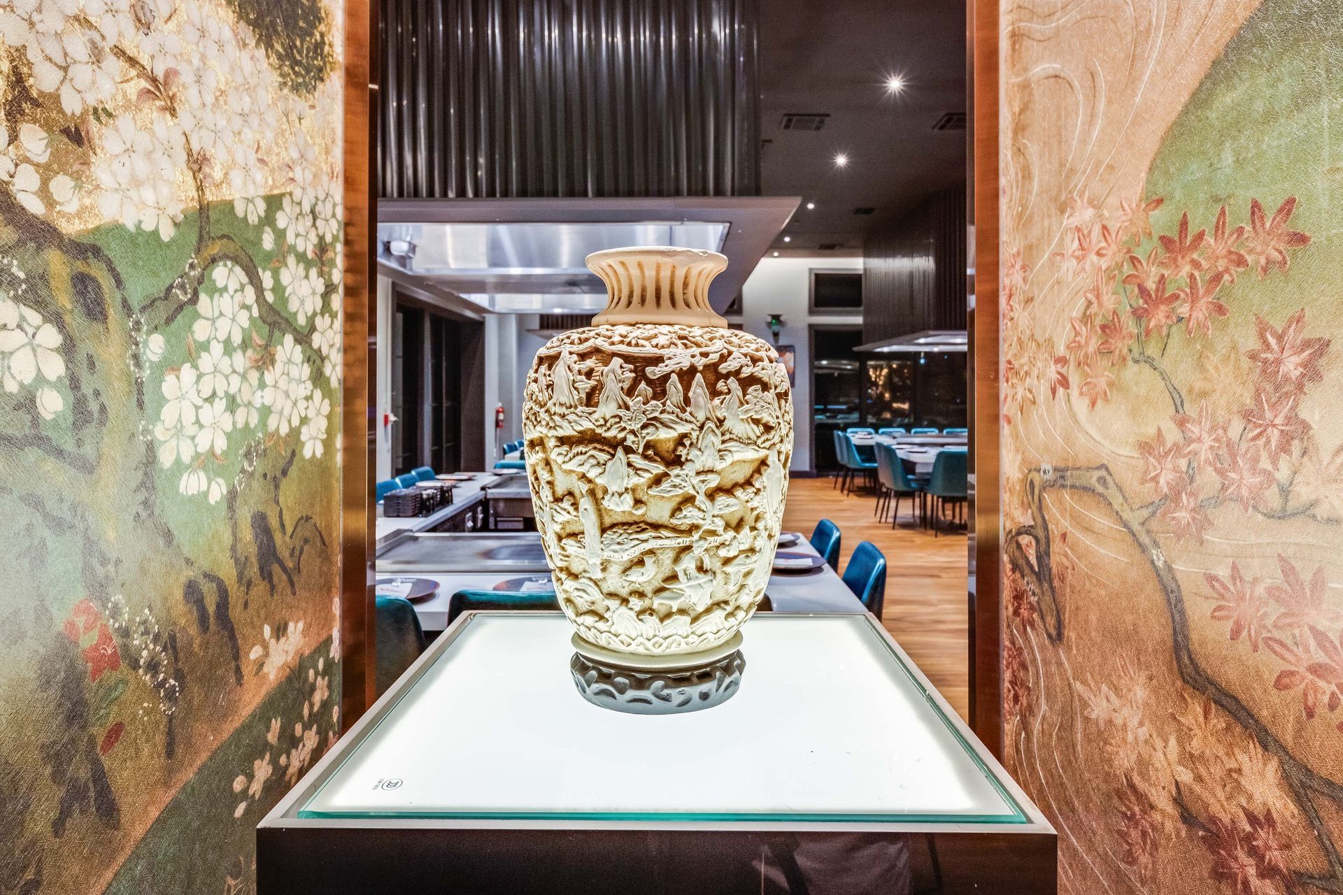 A large vase is sitting on a table in a restaurant.