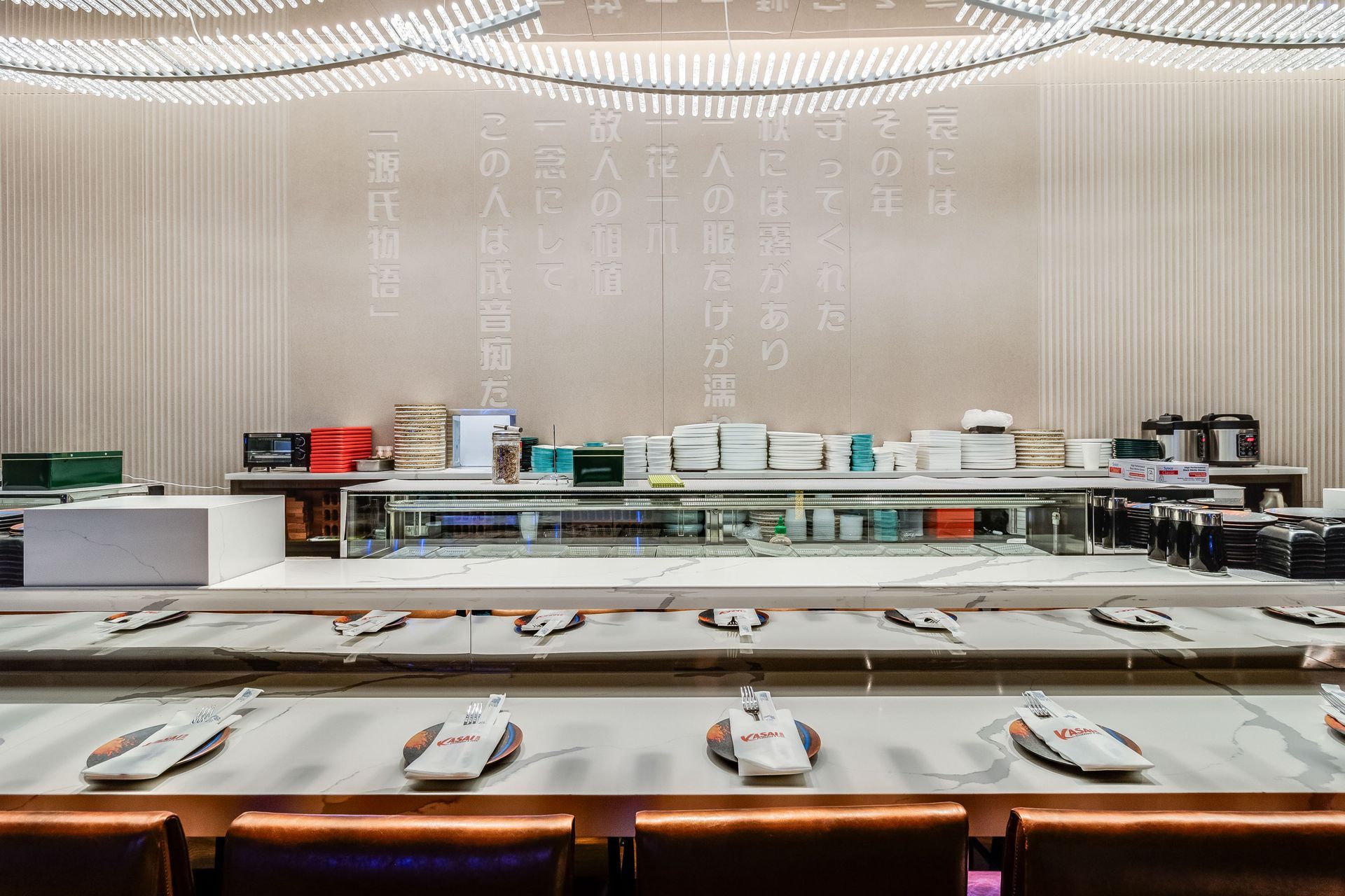 A long table in a restaurant with plates on it.
