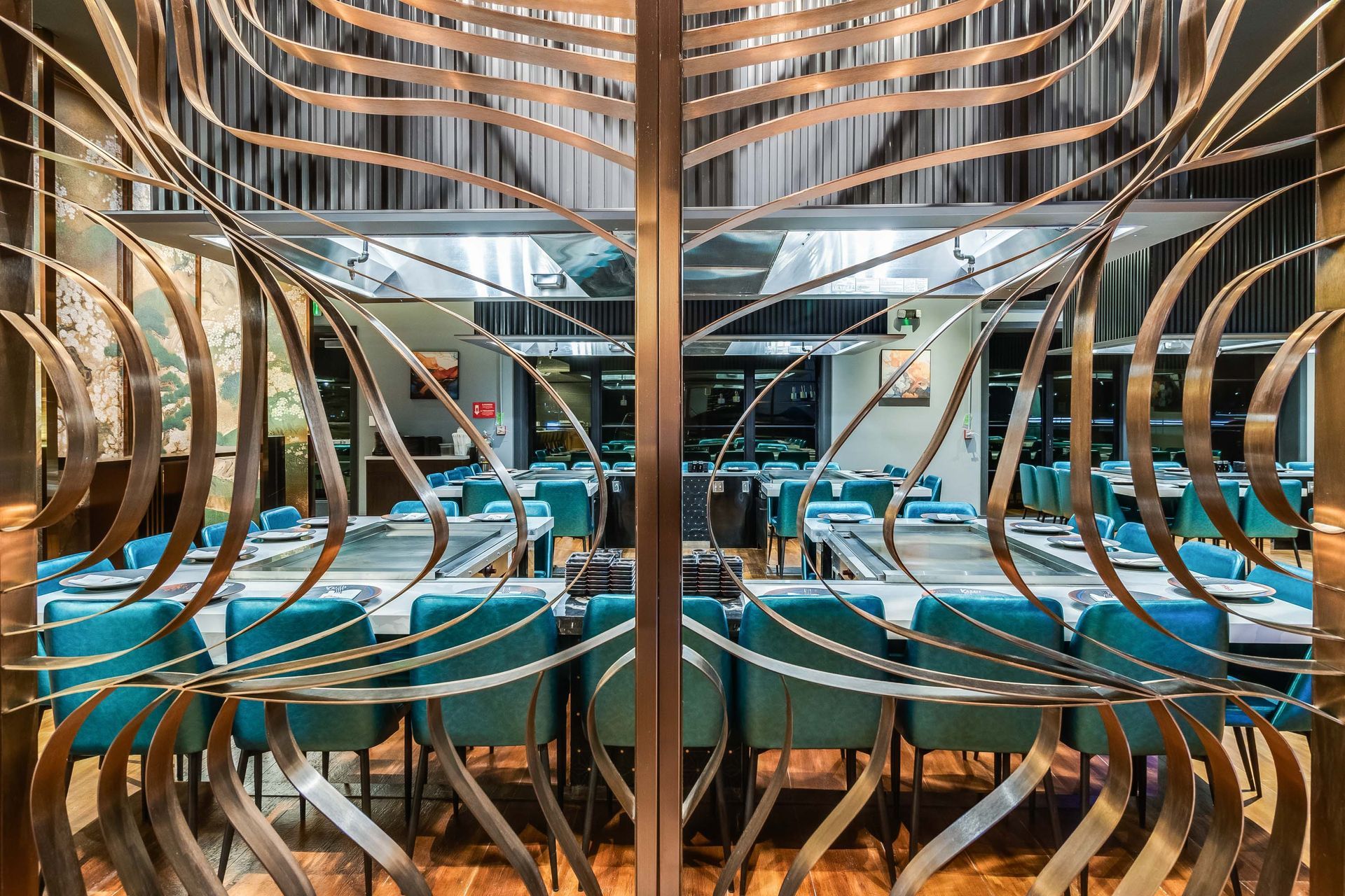 A restaurant with tables and chairs and a stainless steel door.