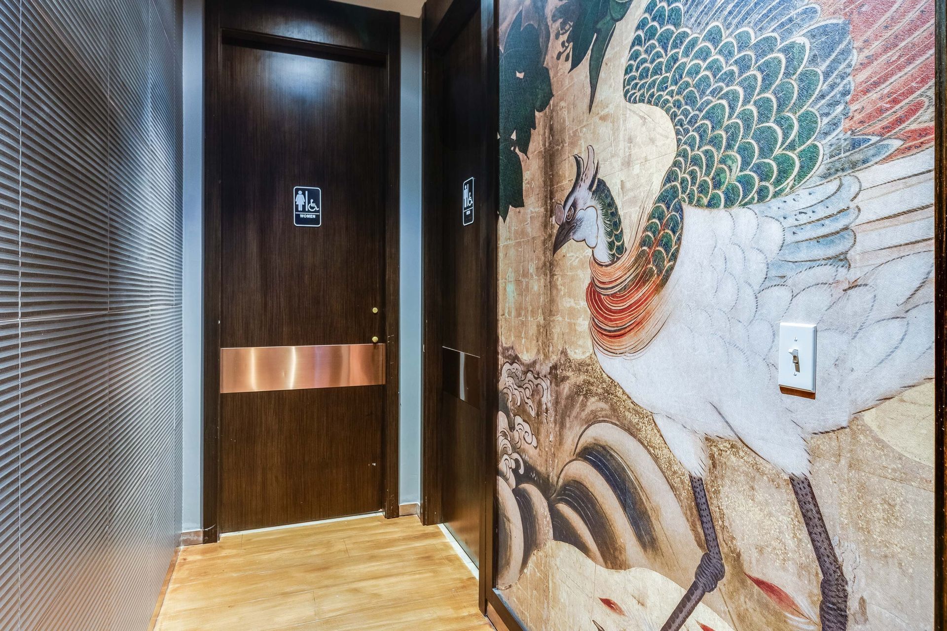 A hallway with a door and a painting on the wall.