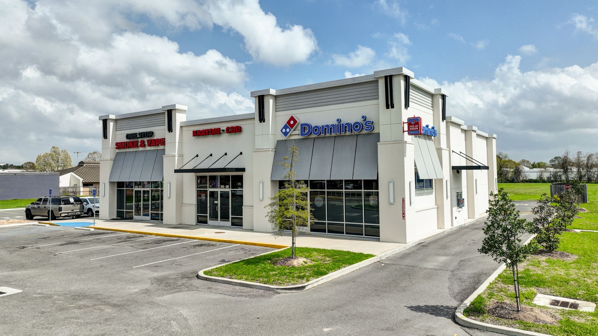 A domino 's pizza restaurant with a parking lot in front of it.