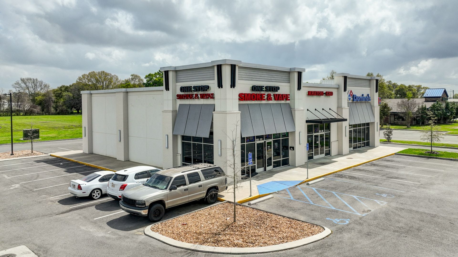A group of cars are parked in front of a store.