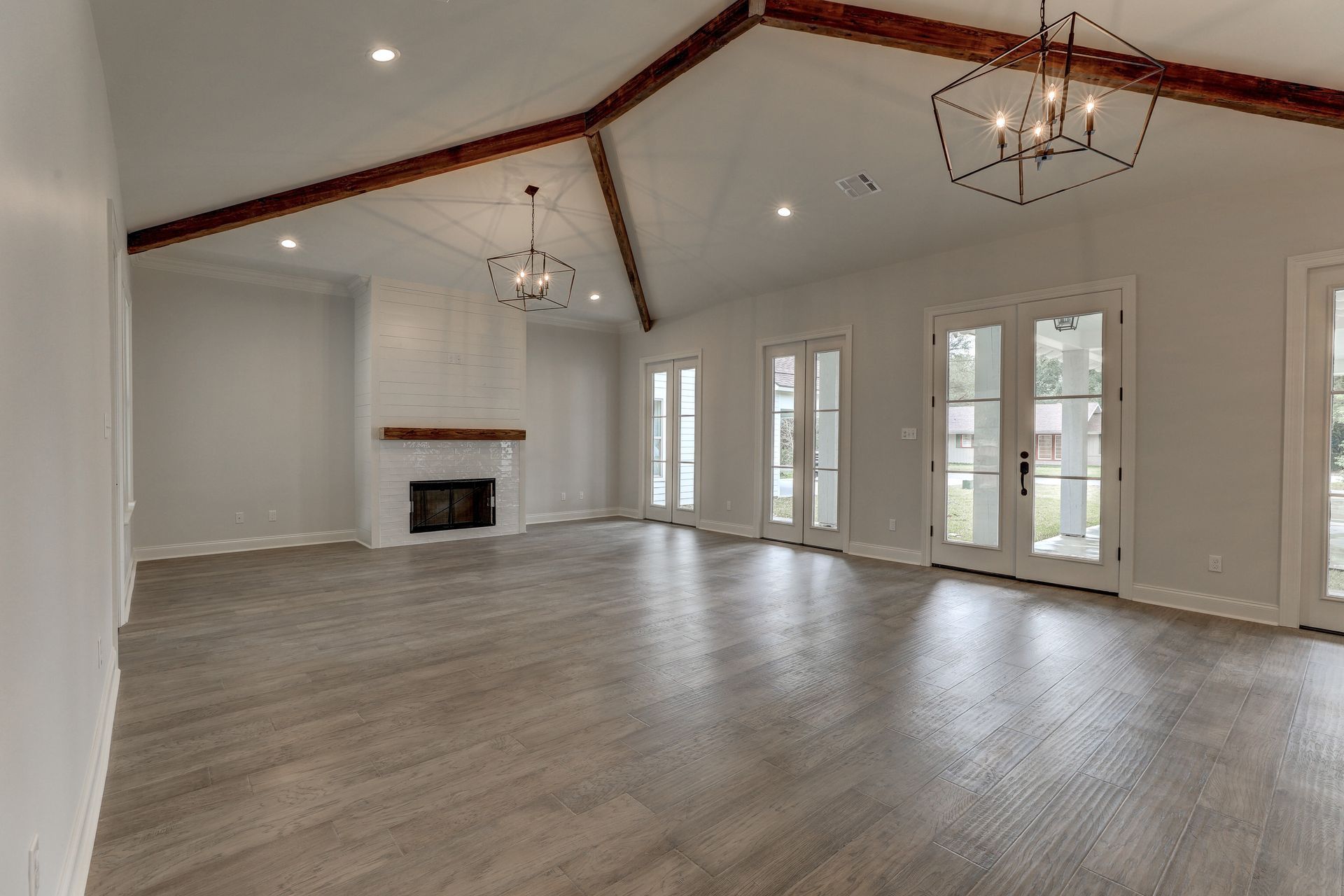 An empty living room with hardwood floors and a fireplace.