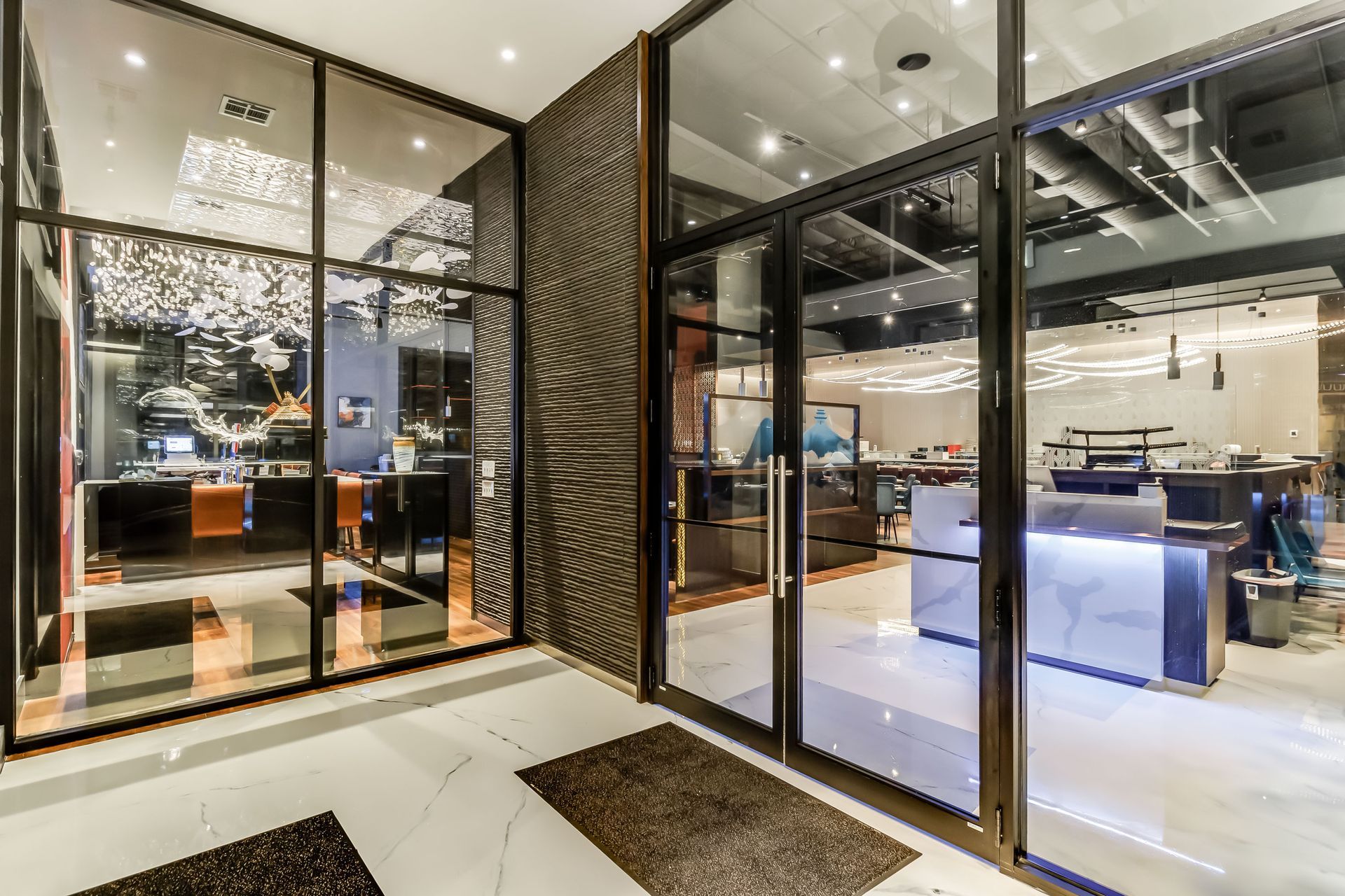 A large glass door leading into a restaurant with a reception desk.