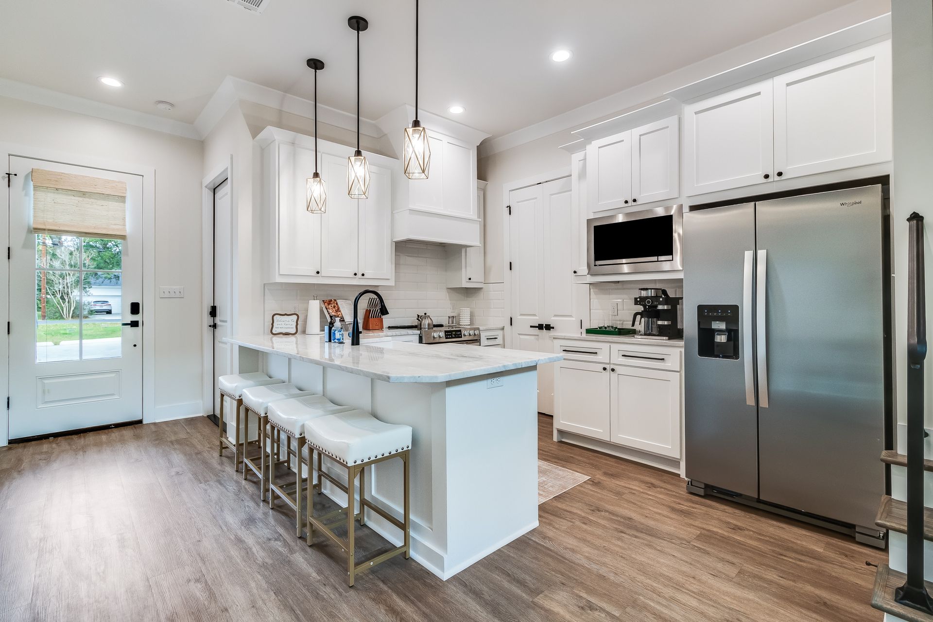 A kitchen with white cabinets and stainless steel appliances.