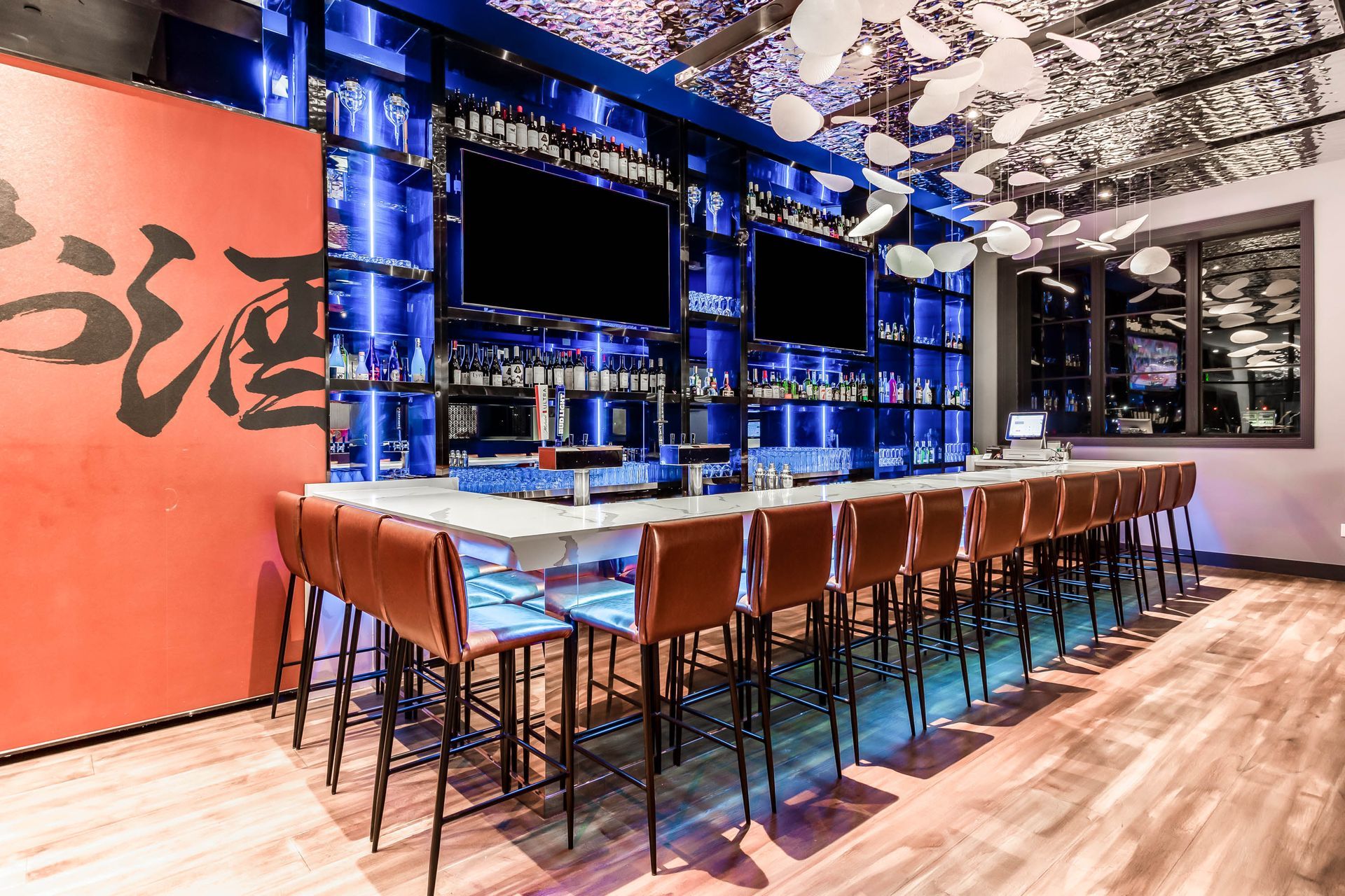 A long bar with a lot of chairs in a restaurant.